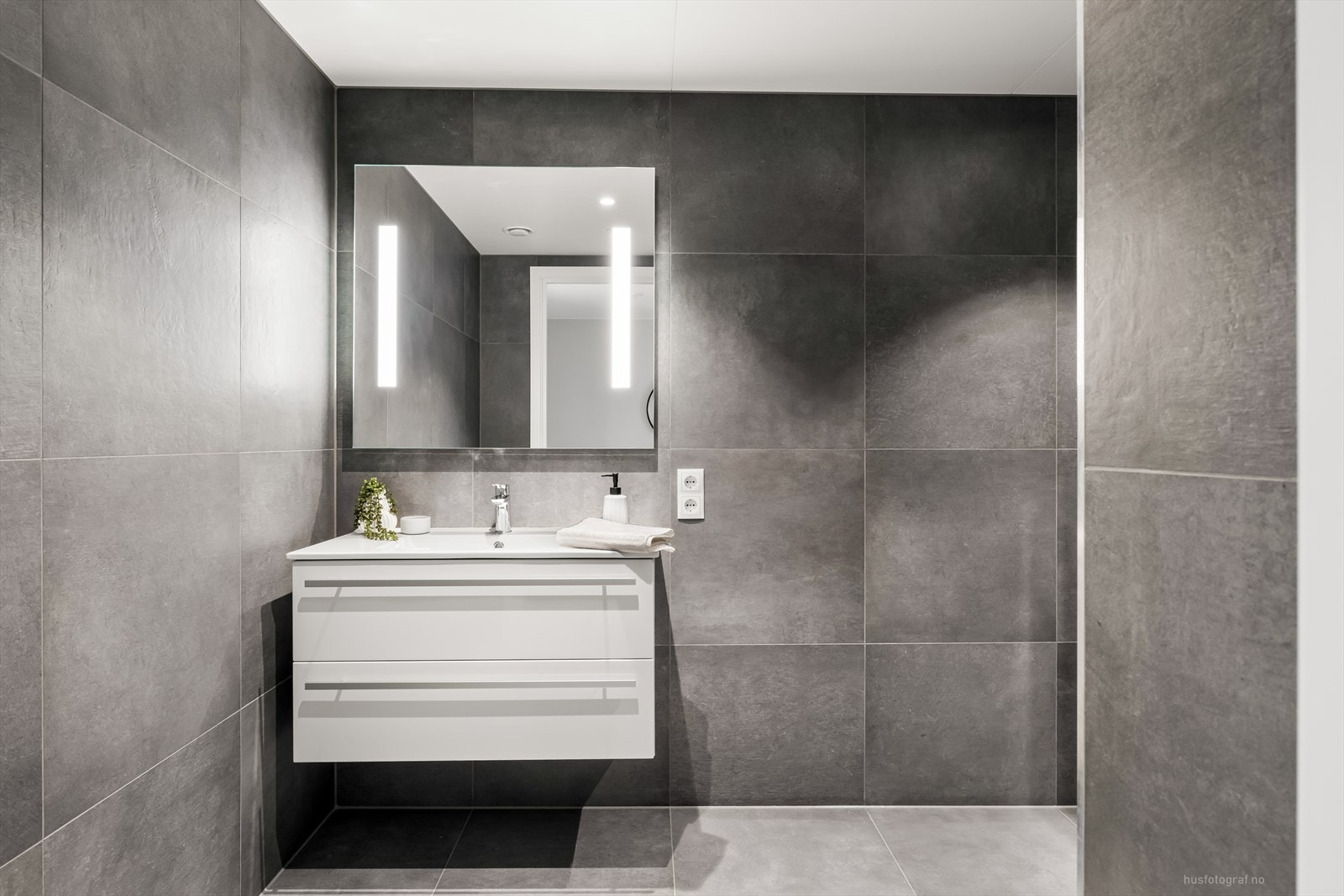 Badet er moderne innredet med store 60x60 fliser, downlights og gulvvarme. Galleribilde