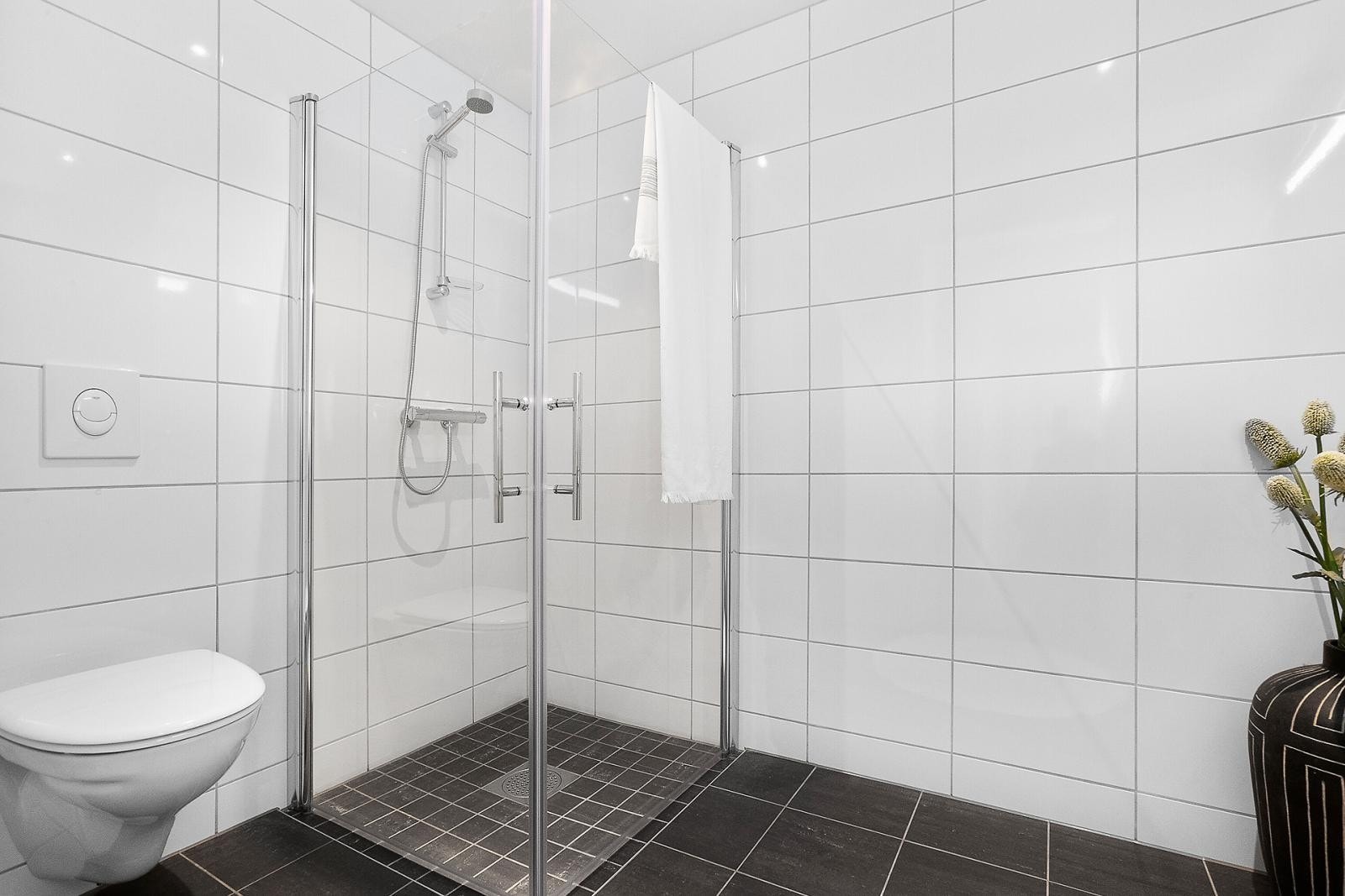 Badet har dusjhjørne, med dører som kan skyves inn for å utnytte plassen bedre Galleribilde