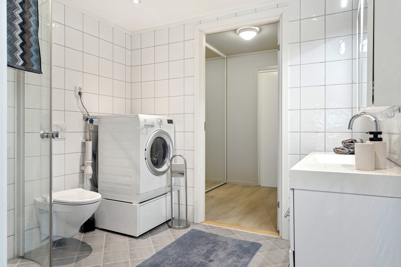 Helfliset bad med gulvvarme, vegghengt wc, innredning, innfellbare dusjdører og innredning. Adkomst via walk-in-garderobe eller gang. Galleribilde