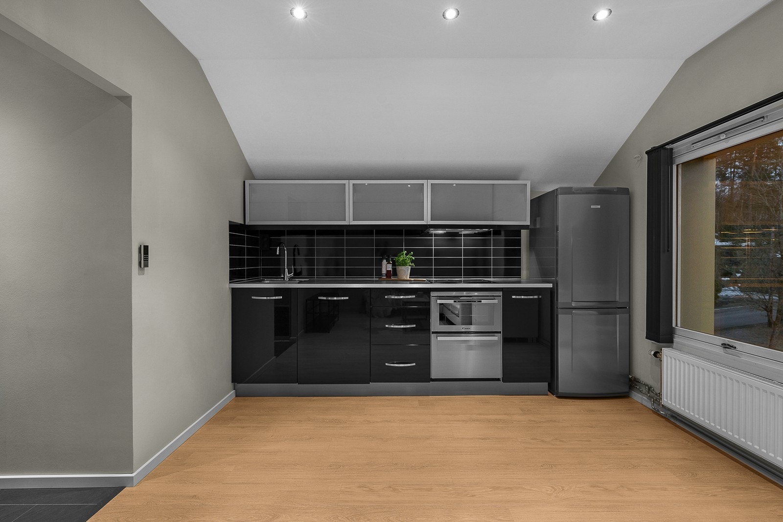 Hvitevarer består av platetopp, kombinert stekeovn/ oppvaskmaskin, kjøl/fryseskap og vaskemaskin i kjøkkenskap Galleribilde