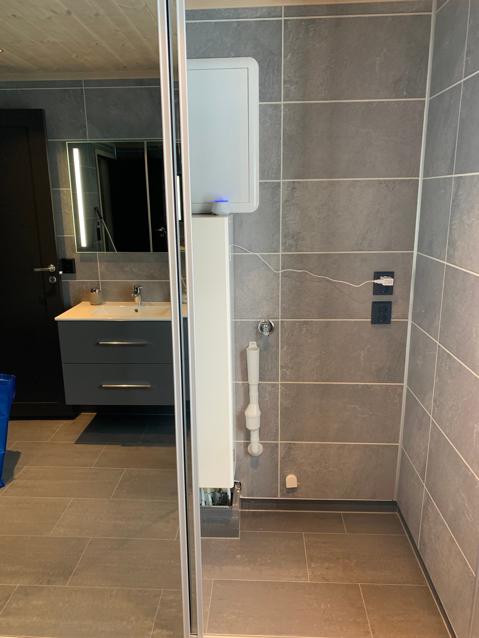 Foto fra visningshytte. Opplegg til vaskemaskin og tørketrommel bak skyvedører på bad. Galleribilde