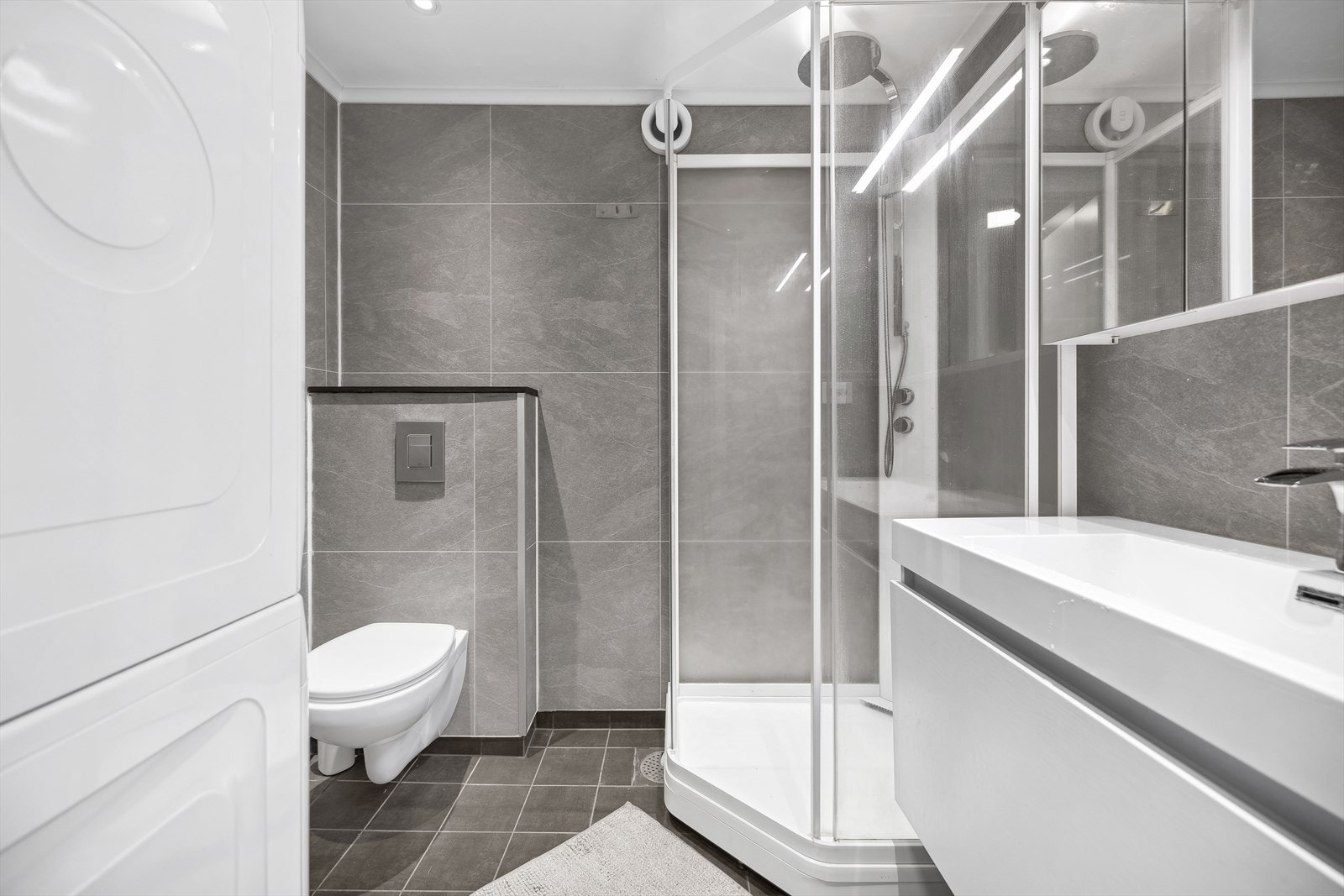 Tidløst baderom som ble pusset opp i 2020. Badet har fliser på gulv med varmekabler, våtromsplater på vegger og spotter i himling. Galleribilde