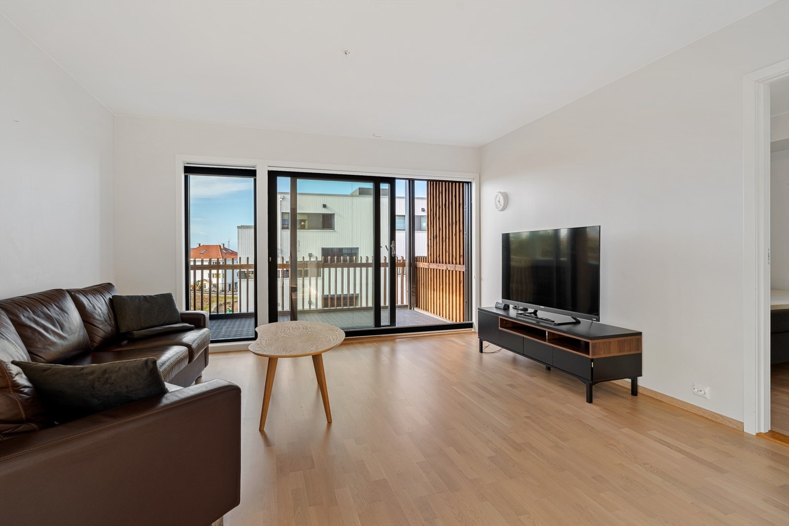 Stue og kjøkken i åpen løsning. Listfrie overganger mellom tak vegg. Lys eikeparkett på gulv. Galleribilde