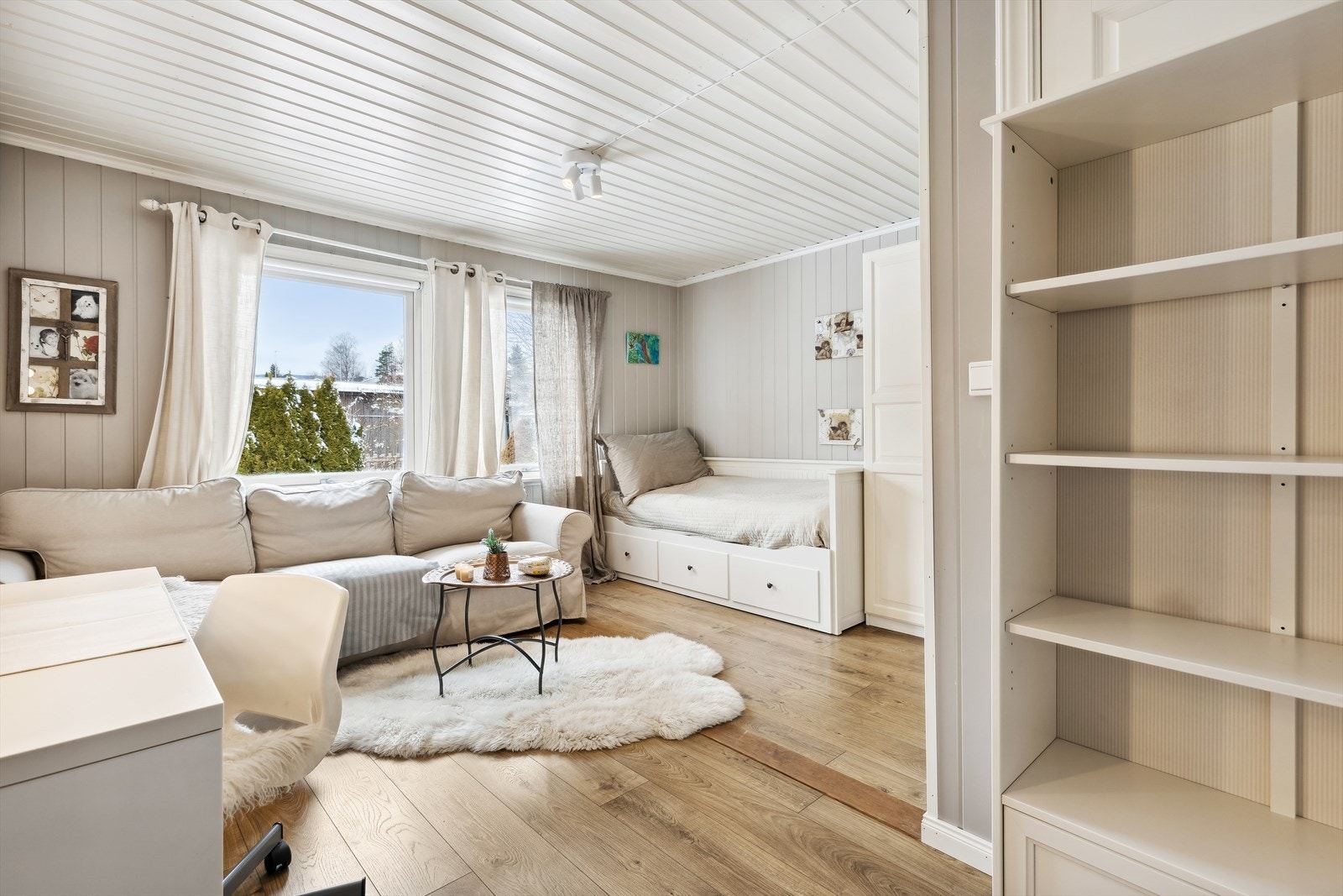 Bak bokhyllen ser du døren som gikk inn til det tredje soverommet som i dag er fjernet. Har du behov for tre soverom, er det kun å sette tilbake lettveggen, så er du i mål. Galleribilde