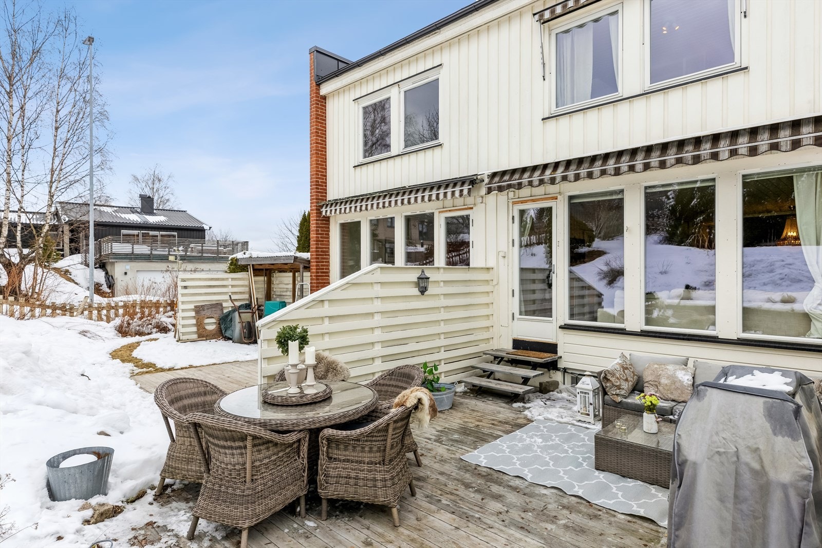 Støttemur i enden av terrassen opp mot skråningen hvor man har plen og tujahekk på toppen. Galleribilde