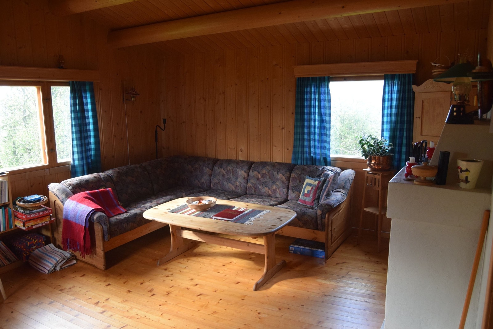 innadørs består stua av en sofakrok med peis og godt med lys fra vinduene. Galleribilde