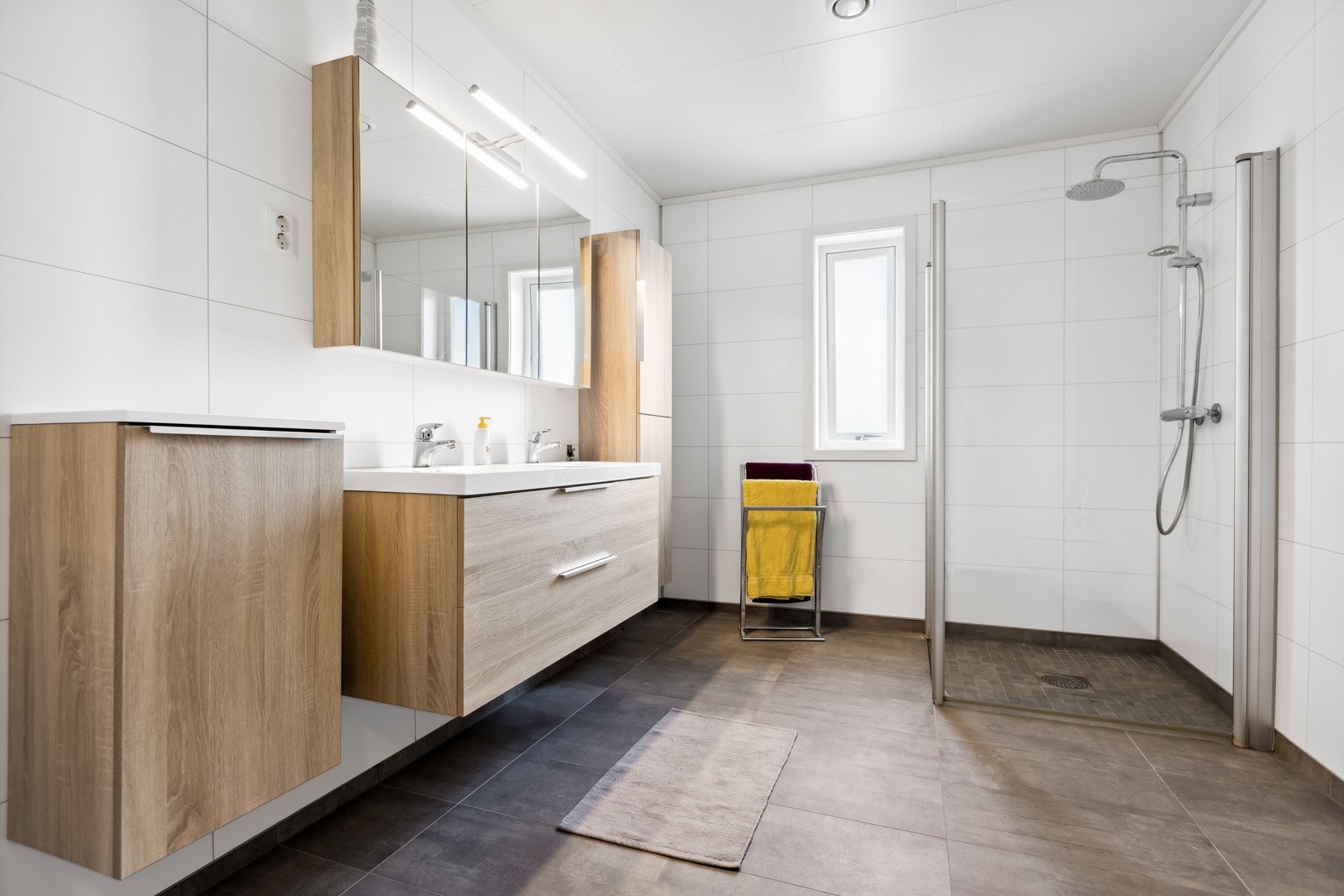 - Badet er romslig med dusjhjørne og pen innredning. Det er 30x60 fliser på gulv og plater på vegger. Galleribilde