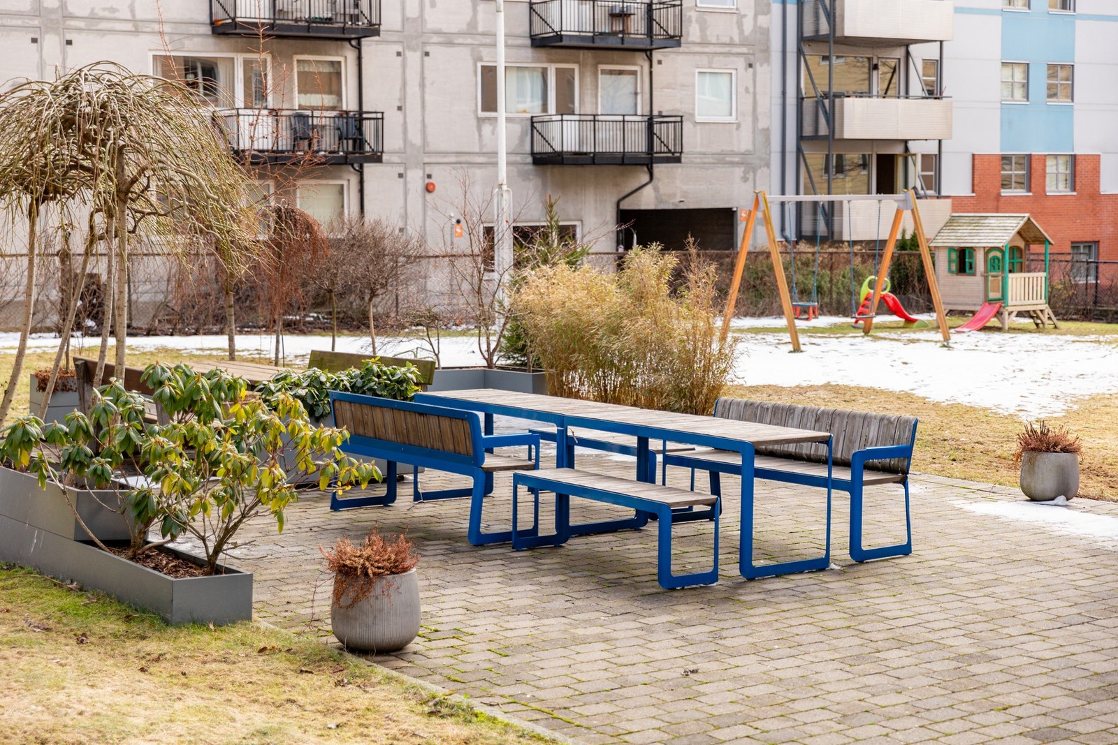 Koselig bakgård med sittegrupper, beplantning og lekeapparater. Galleribilde