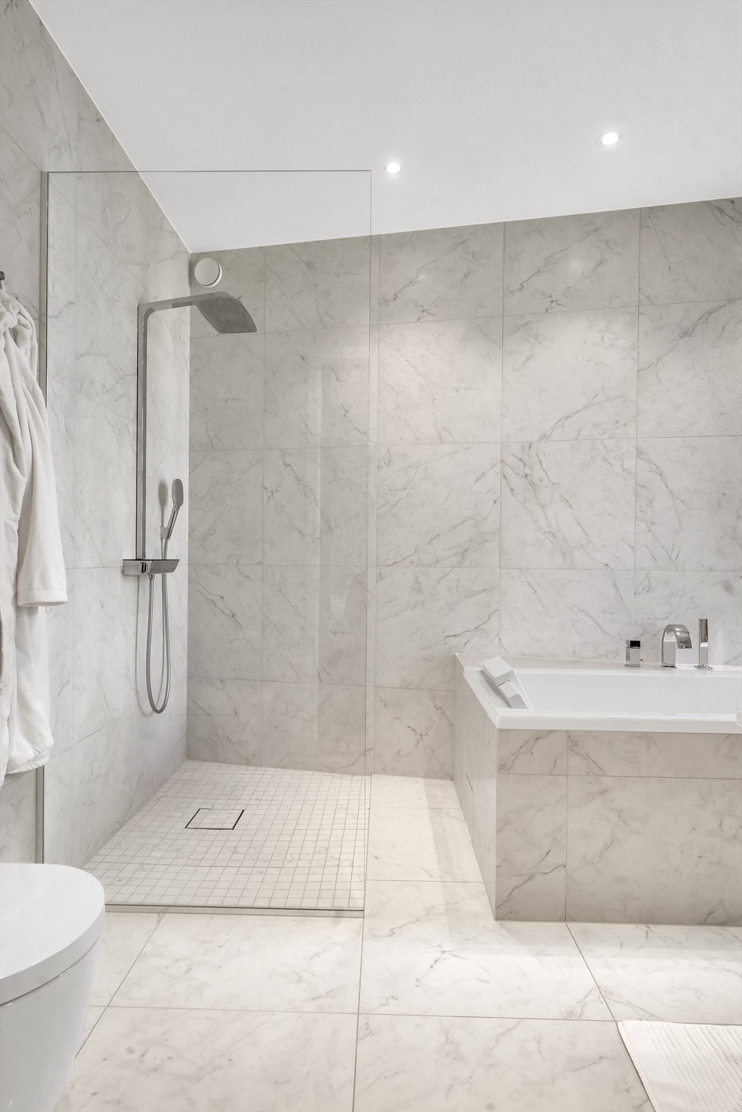 Badet består av flislagt gulv med varmekabler, flislagte vegger og malt himling Galleribilde