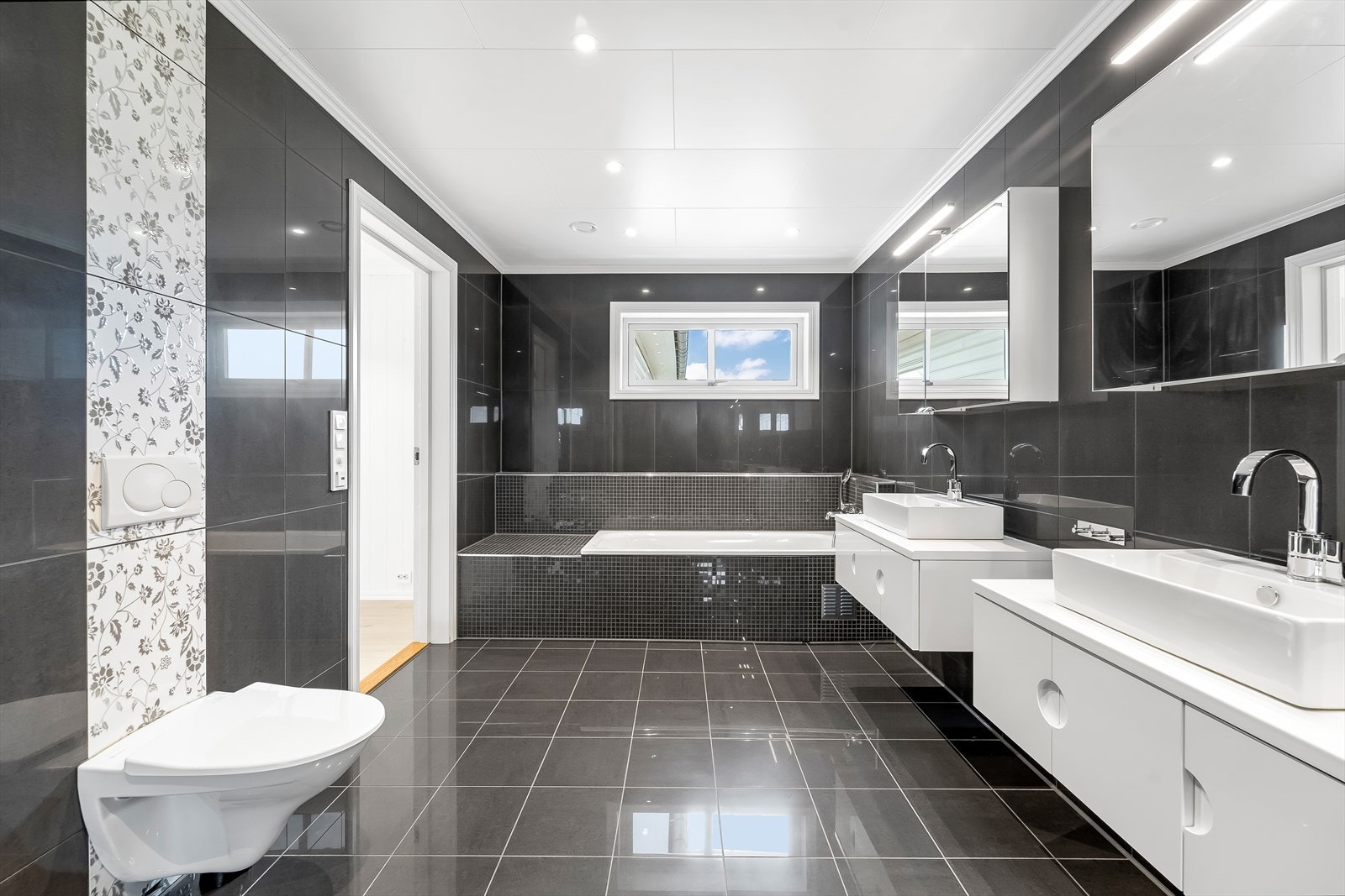 Badet er innredet med dobbel baderomsinnredning, vegghengt toalett og badekar. Galleribilde