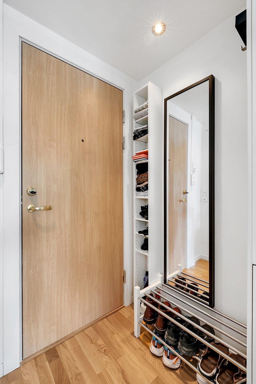Lys og praktisk entré med plass til yttertøy og sko. Med dørcallinganlegg slipper du gjestene enkelt inn fra bakkeplan. Downlights i taket. Galleribilde
