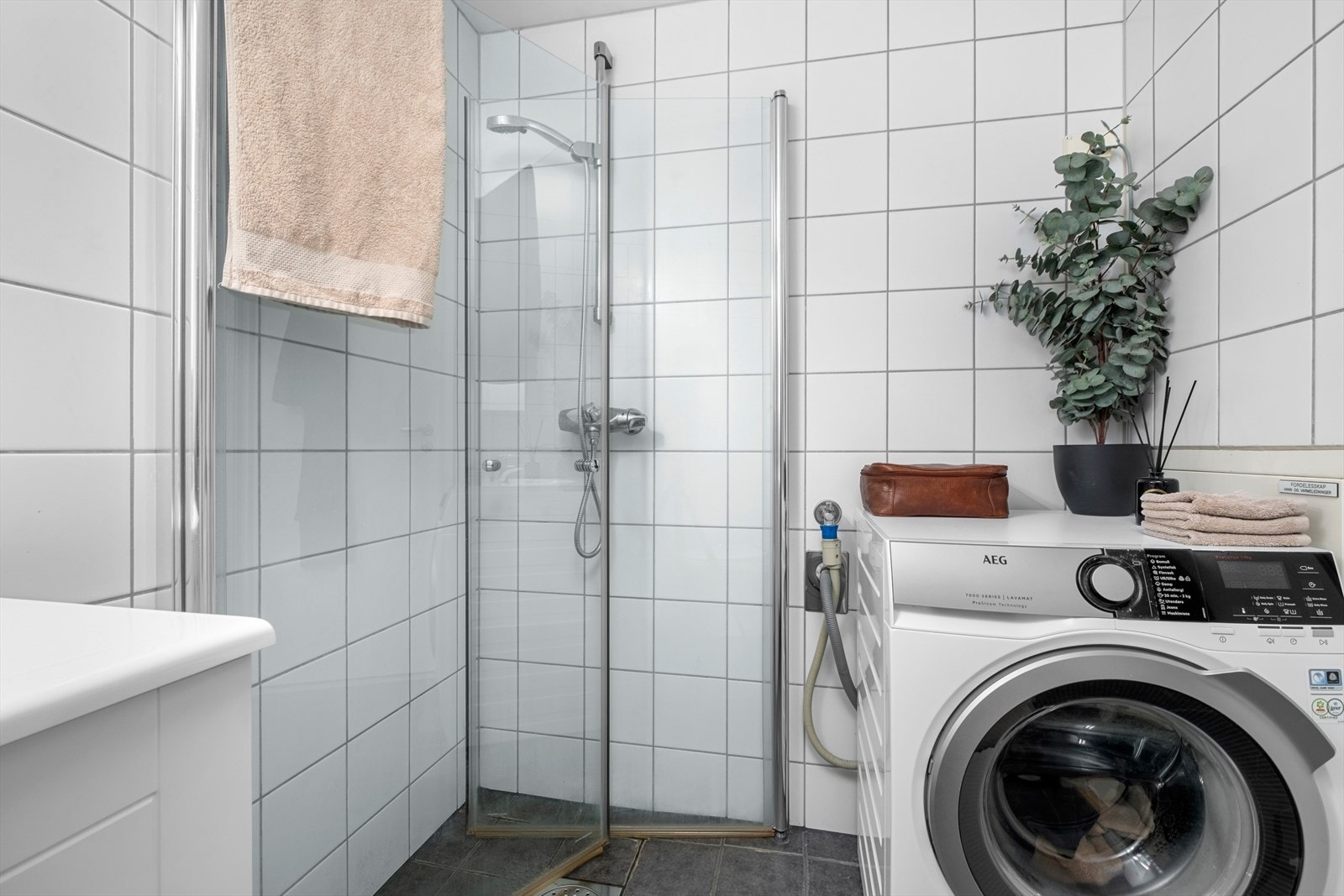 Her får du en arealeffektiv dusjløsning, flott baderomsinnredning og ferdig opplegg for vaskemaskin. Galleribilde