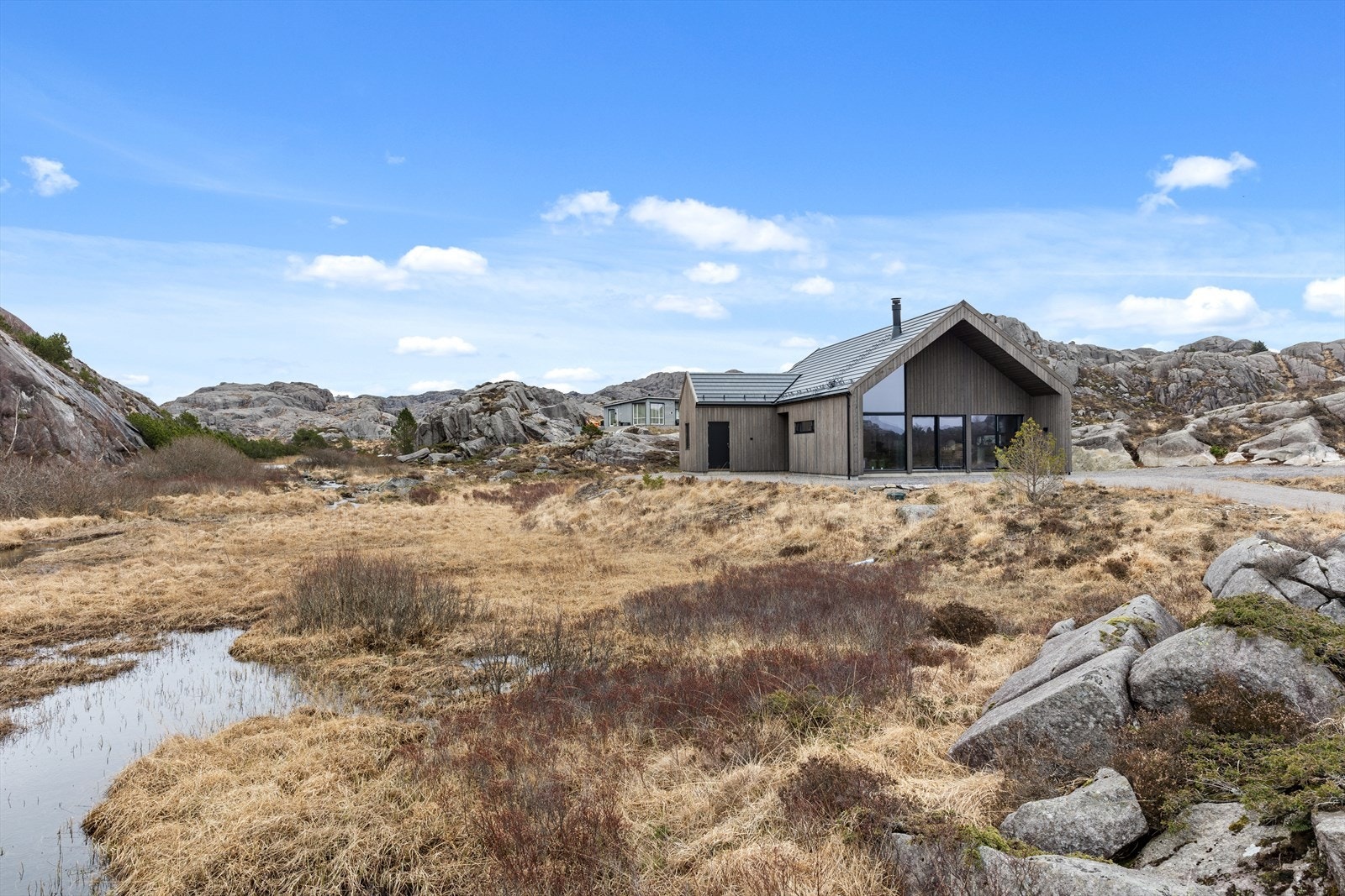 Hytten har flat takstein, svart alu takrenner og nedløp Galleribilde