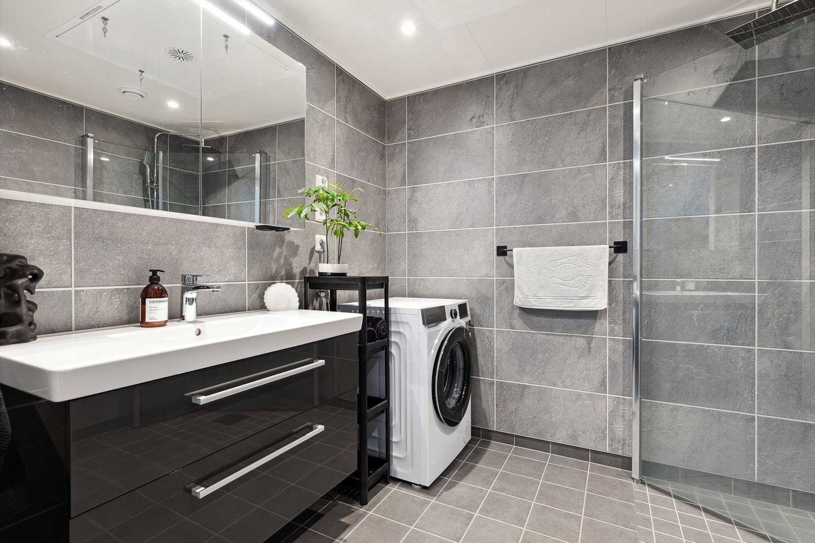 Baderomsinnredning med skuffer i underkant, heldekkende servant og speilskap med belysning i overkant. Galleribilde