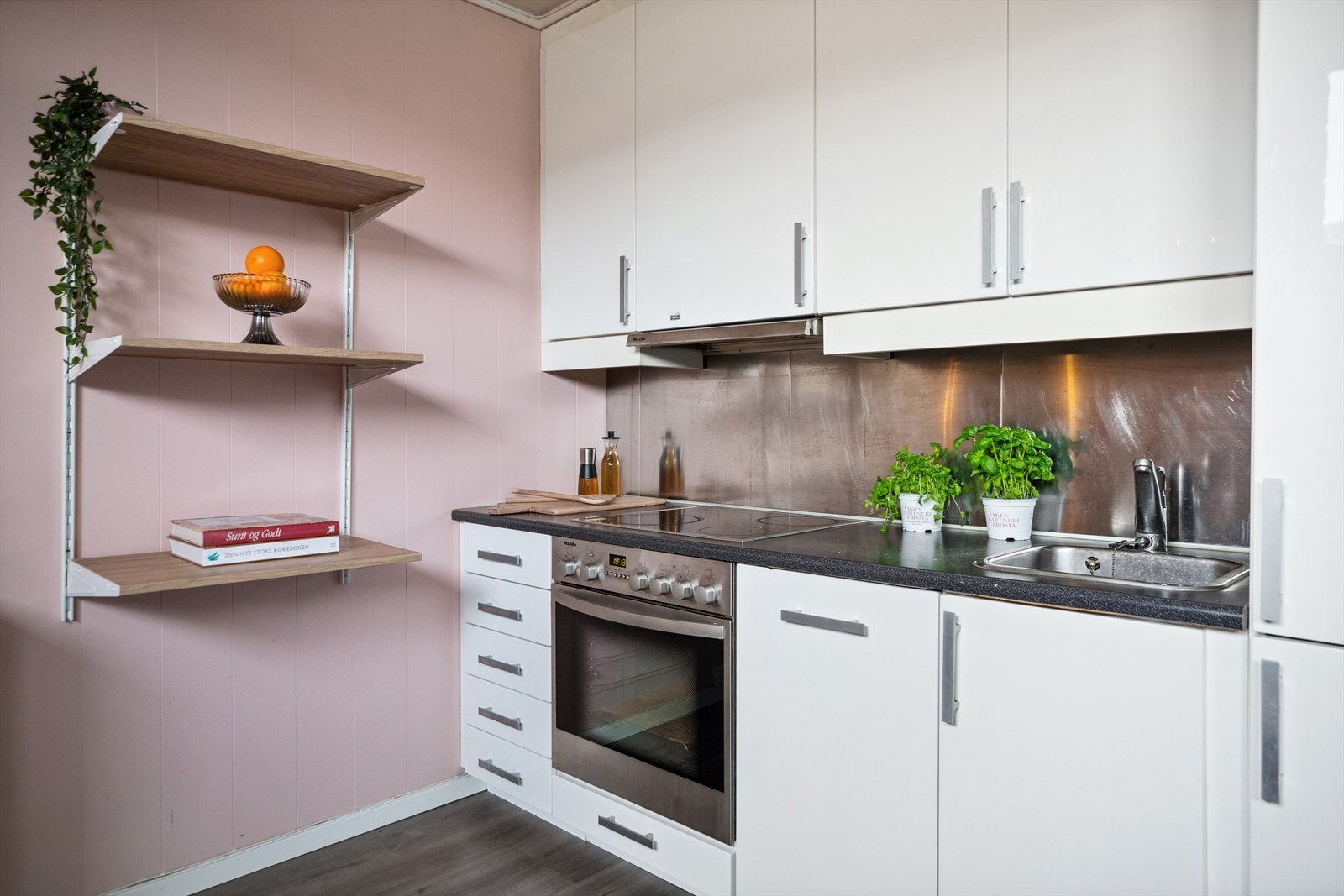 Koketopp og oppvaskkum er nedfelt i benkeplaten, og over er det ventilator og plater på veggene. Galleribilde