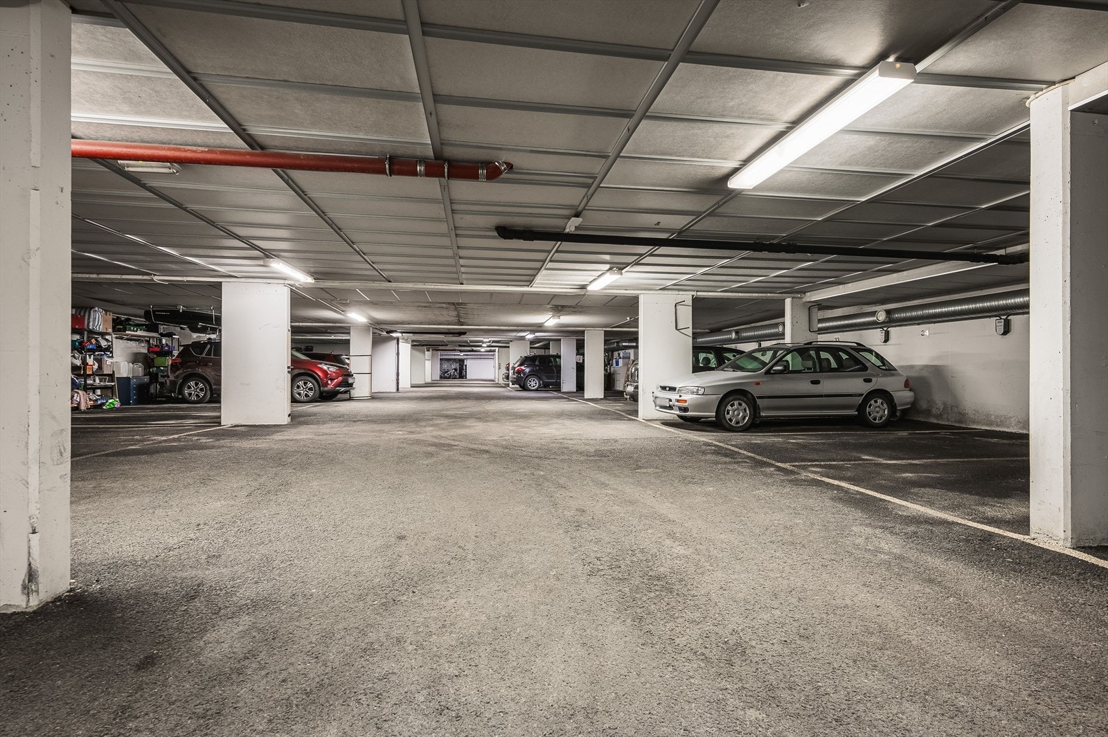 Tilhørende parkeringsplass i felles, lukket garsjekjeller. Enkel akomst via heis fra leiligheten. Felles innkjøring med elektrisk port. Elbil-lader Galleribilde