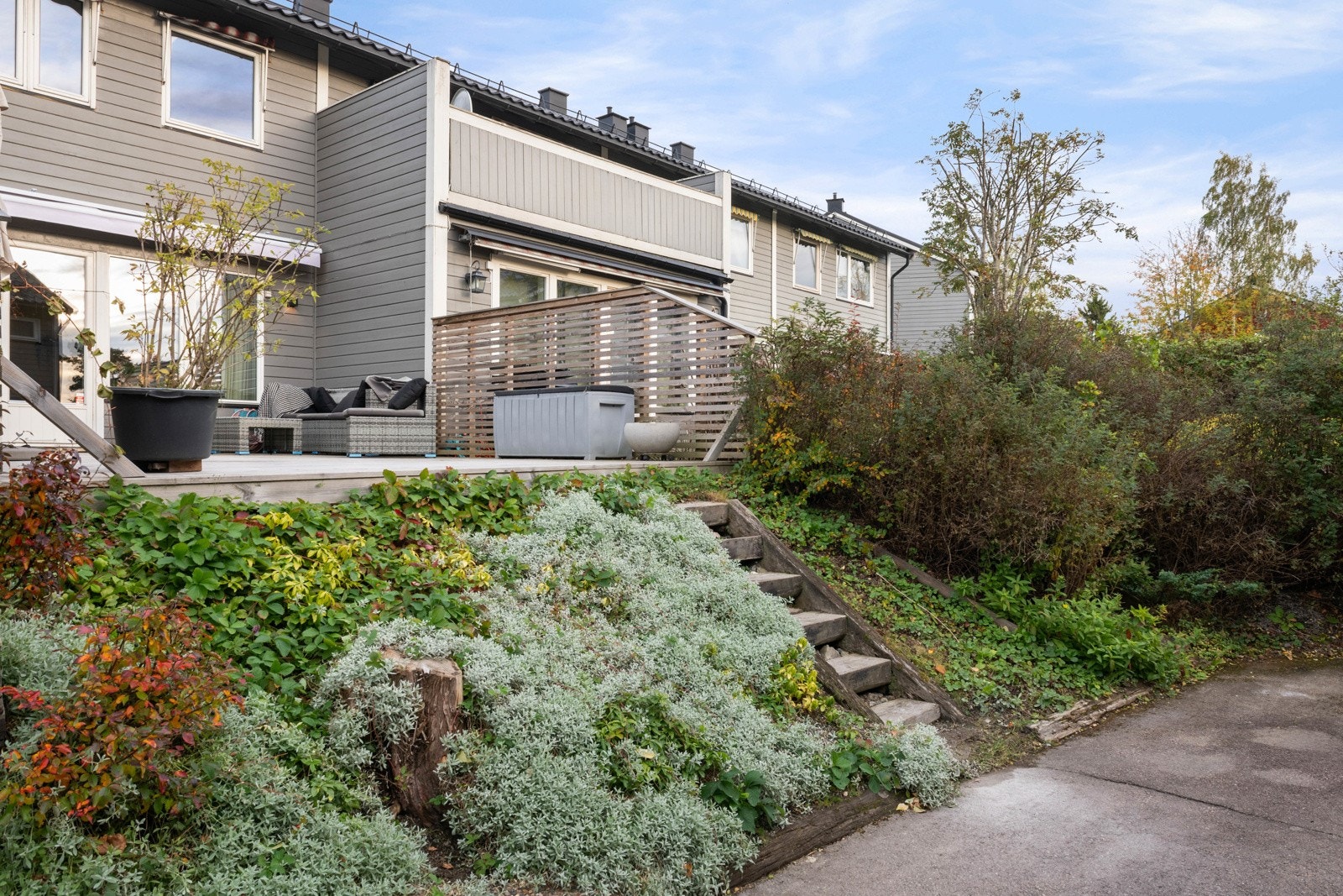 Pent beplantet skråning nedenfor terrassen med trappeadkomst. Galleribilde