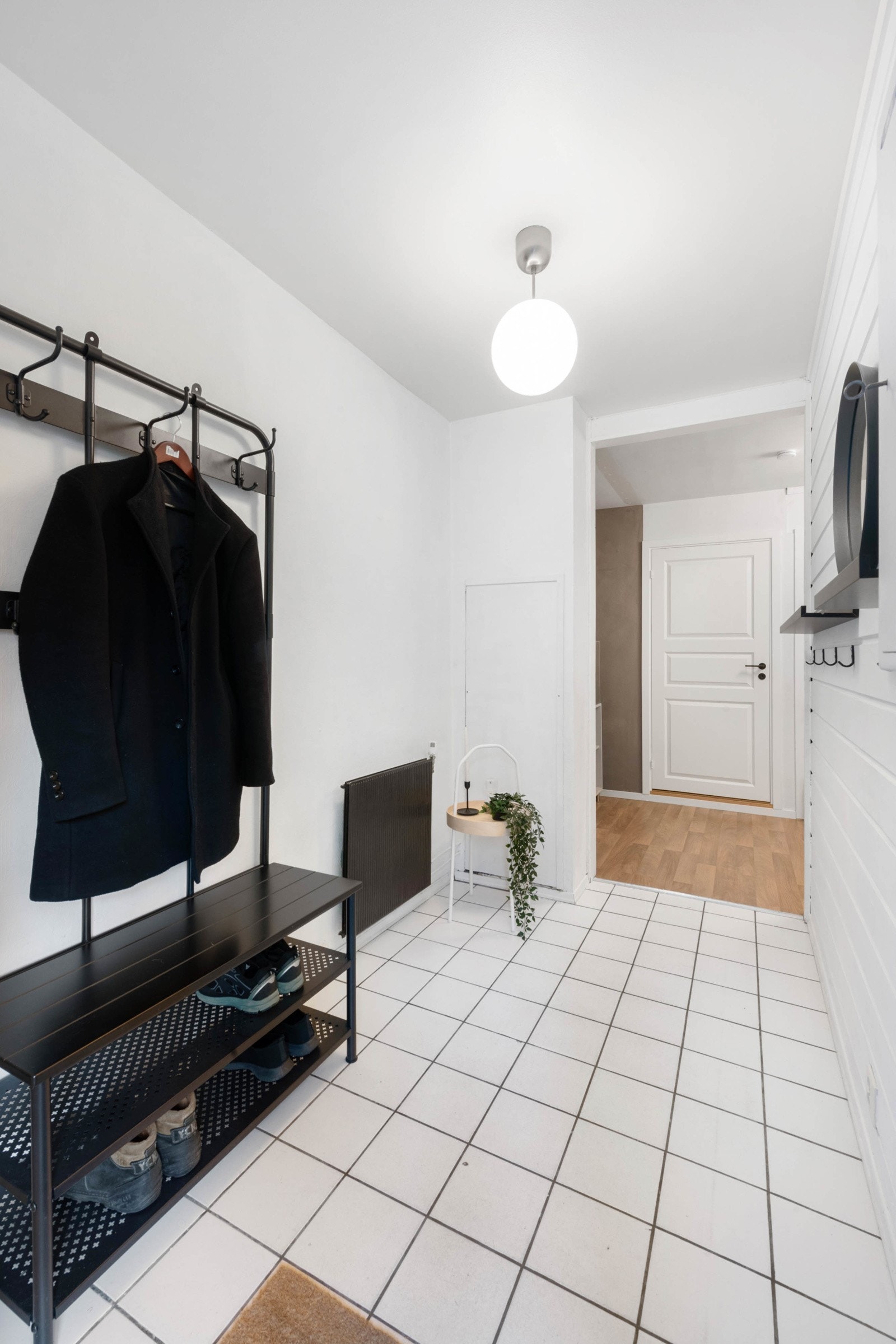 Entré med flislagt gulv, malte vegger - en med liggende, malt panel, åpen garderobeløsning, radiator med fjernvarme, sikringsskap og teknisk skap. Galleribilde