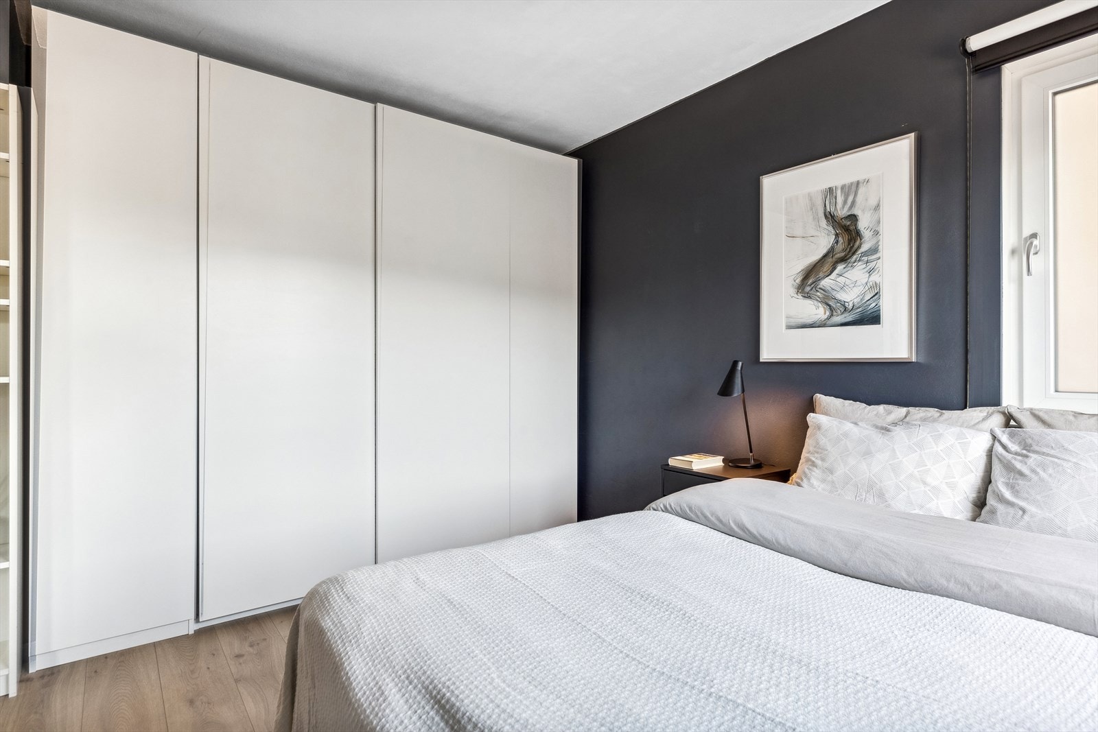 Langs den ene veggen har soverommet en stor og plassbygd skyvedørsgarderobe med mye oppbevaringsplass. Galleribilde