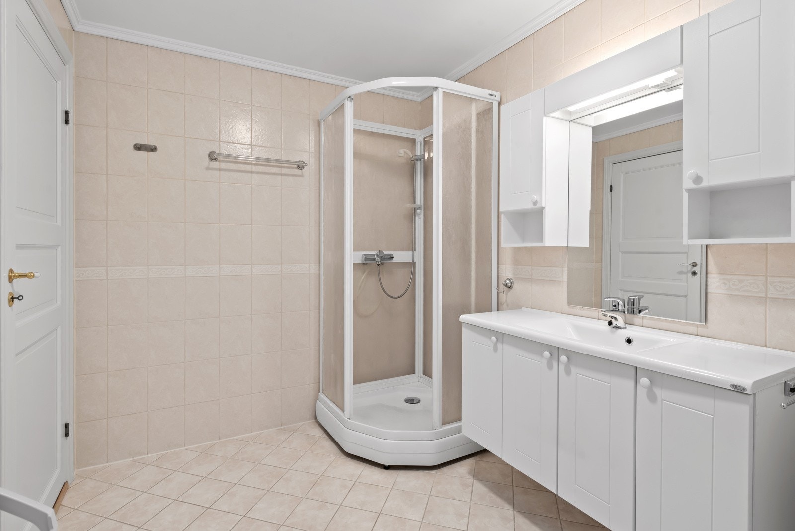 Badet er utstyrt med dusjkabinett, toalett, baderomsinnredning og opplegg for vaskemaskin Galleribilde