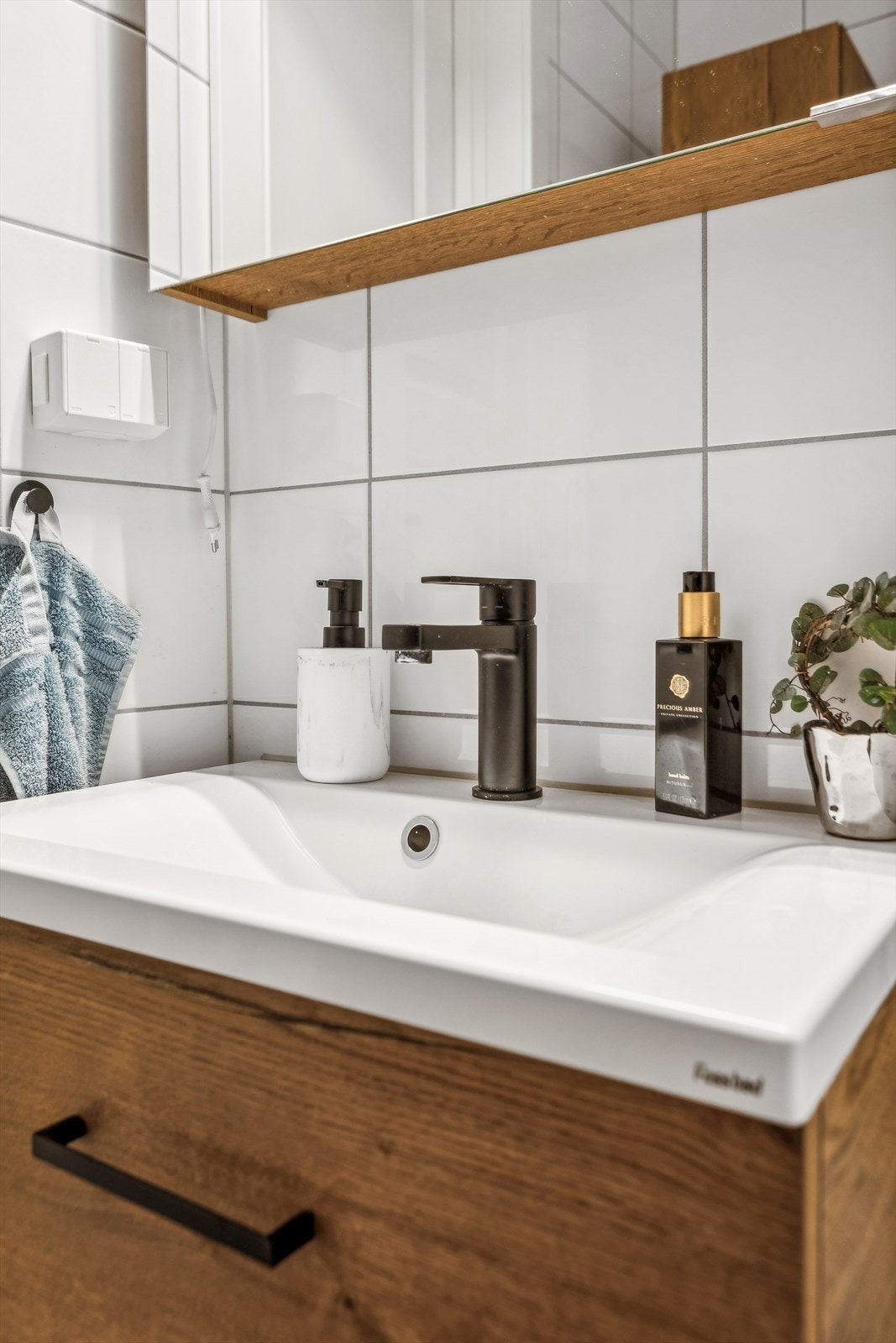 Badet består av vegghengt wc, servant m/ underskap, overskap m/ speilfronter og overlys, veggskap og inn-/utadslående dusjdører. Varmekabler i gulv. Galleribilde
