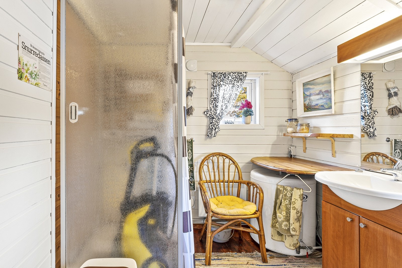 Bad med servantskap og speil, dusjkabinett og varmtvannsbereder. Galleribilde