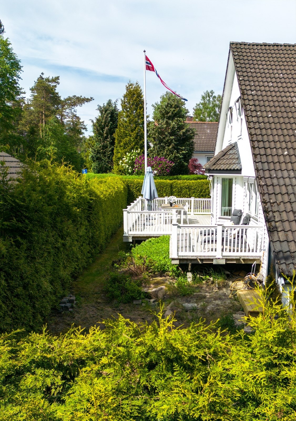 Huset fra 1986 er svært godt vedlikeholdt - innrammet av en velfrisert hekk. Galleribilde