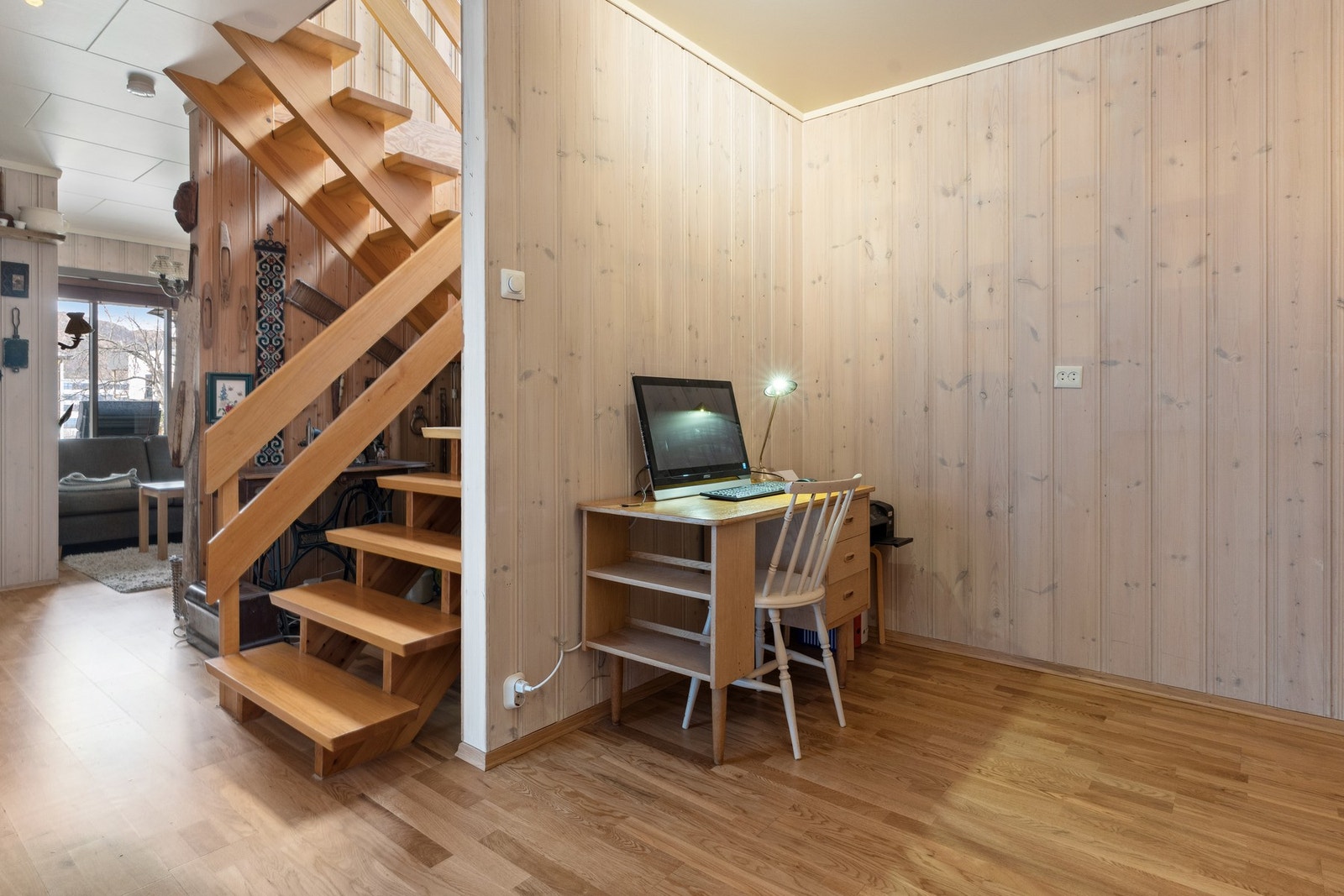 Hallen er av god størrelse og er innredet som kontor i bakkant og tv-stue i front. Det er også vedovn plassert her. Galleribilde