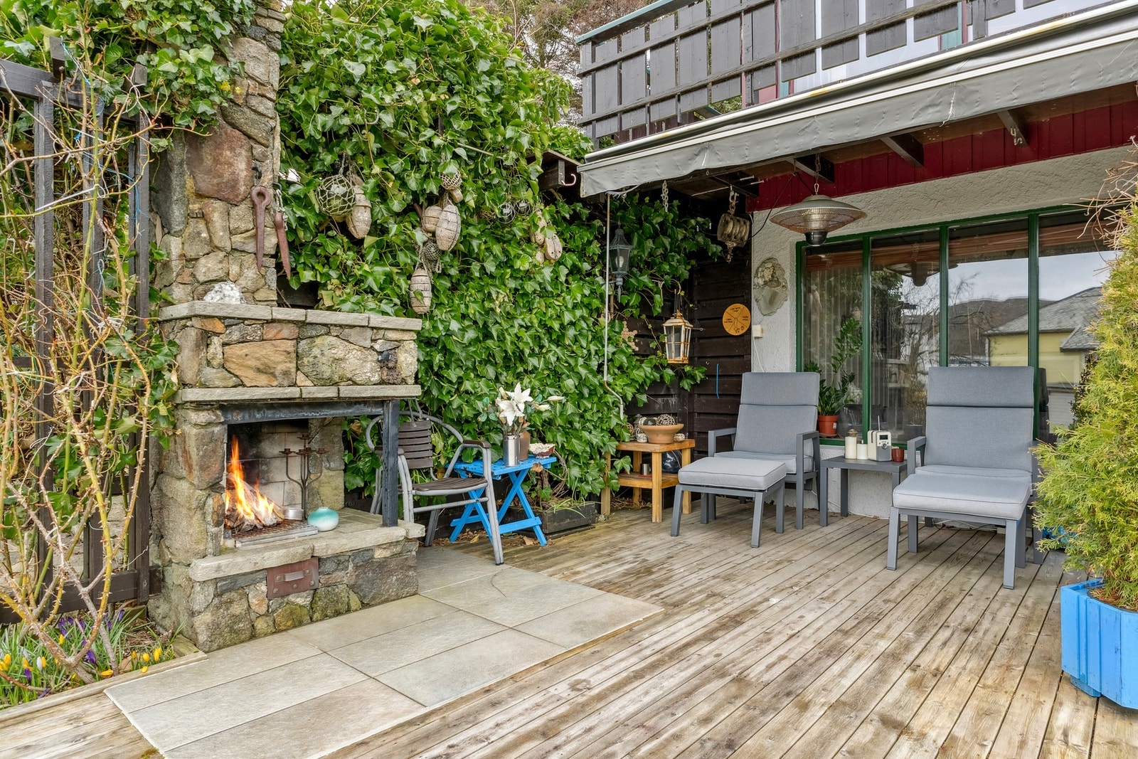 Eiendommen har flere solrike uteplasser - her ved inngangsparti med utepeis. Galleribilde