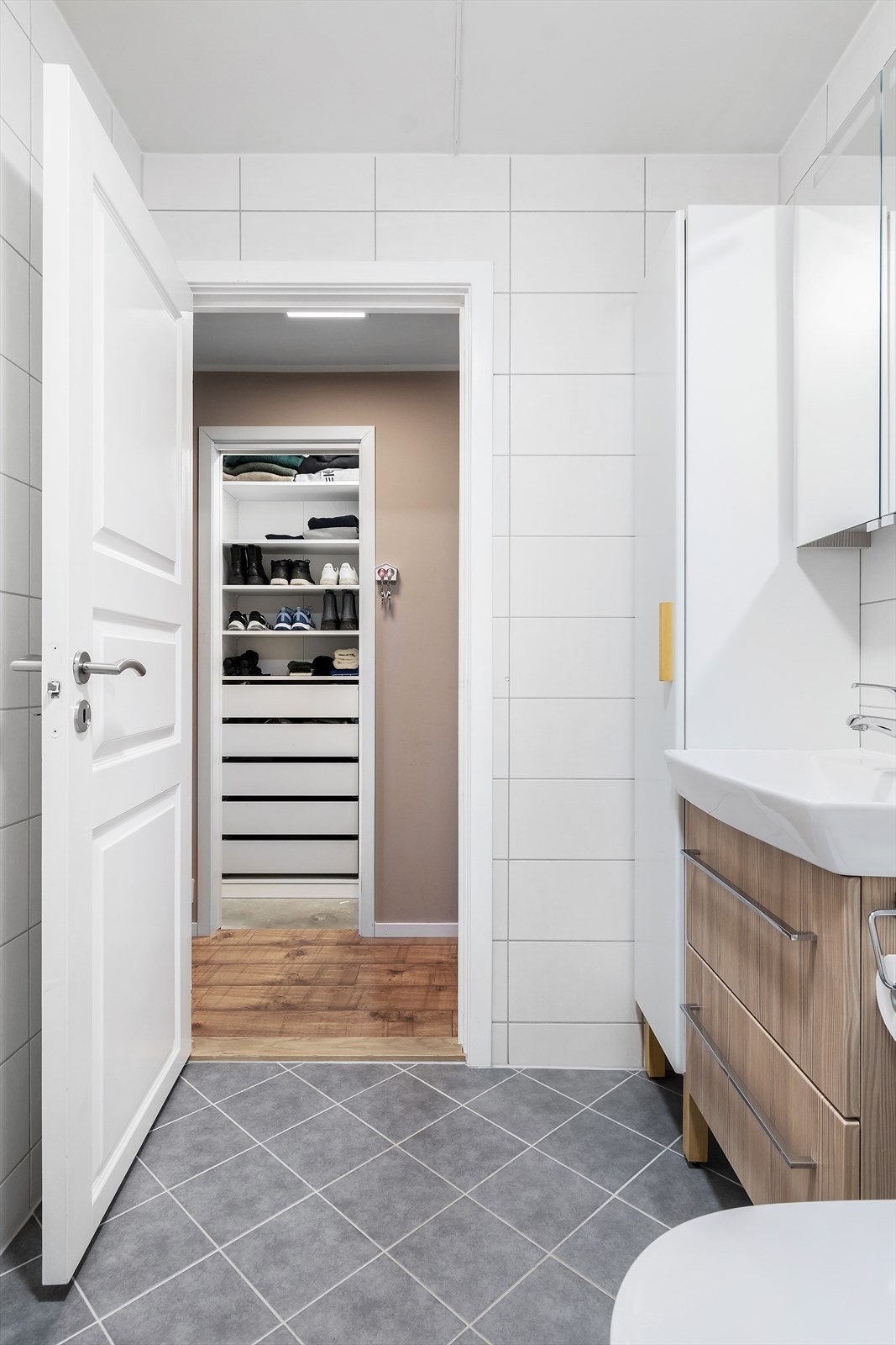 Badet er utstyrt med sideskap, speilskap, servant med underskap, vegghengt toalett og dusjsone. Det er også opplegg for vaskemaskin. Galleribilde