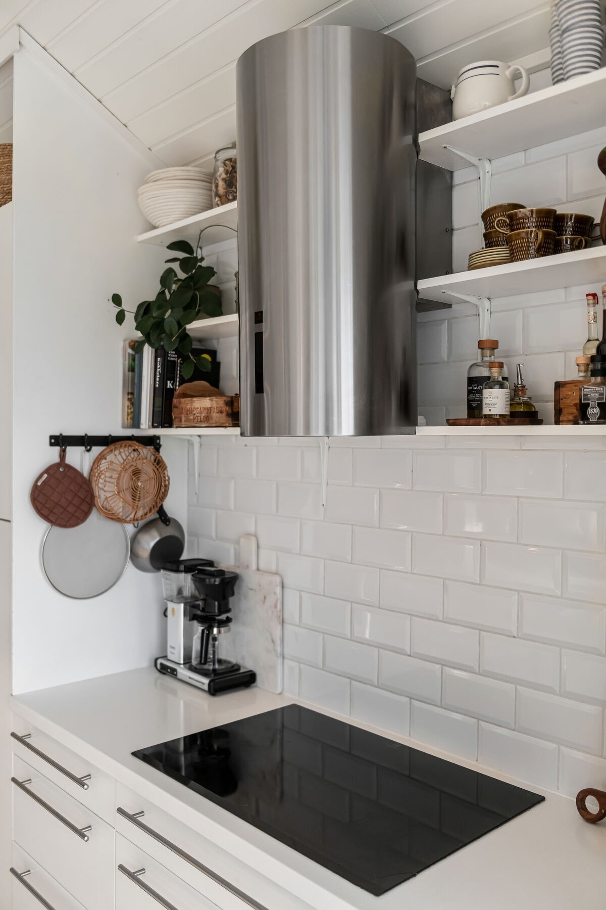 Stilren kjøkkenventilator over den integrerte platetoppen. Galleribilde