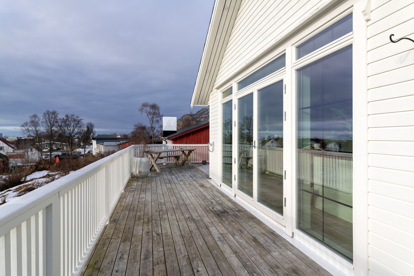 Stor, solrik veranda mot sør, som strekker seg rundt flere sider av boligen. Galleribilde