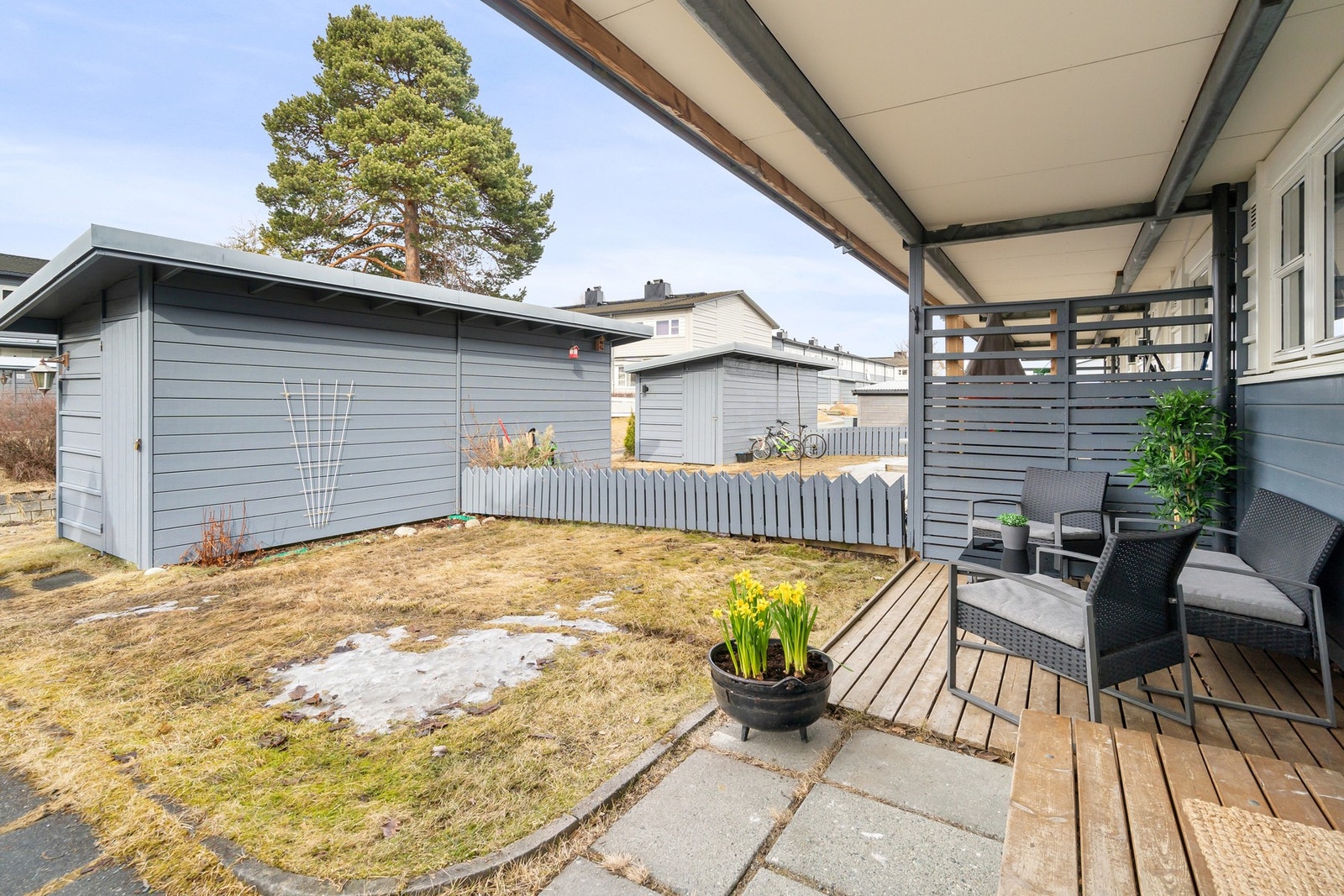 Ved inngangspartiet er det både en terrasse og liten hageflekk. Galleribilde