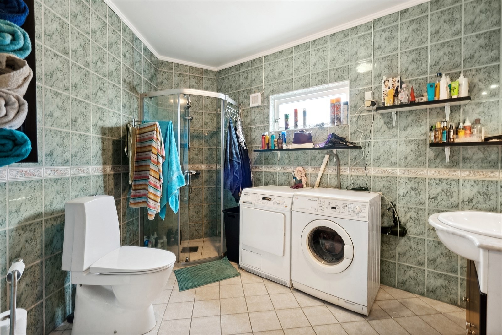 Badet holder en normalt god standard med flis på gulv og vegger, mekanisk avtrekk og dusjhørne, toalett og servant. Opplegg for vaskemaskin. Galleribilde