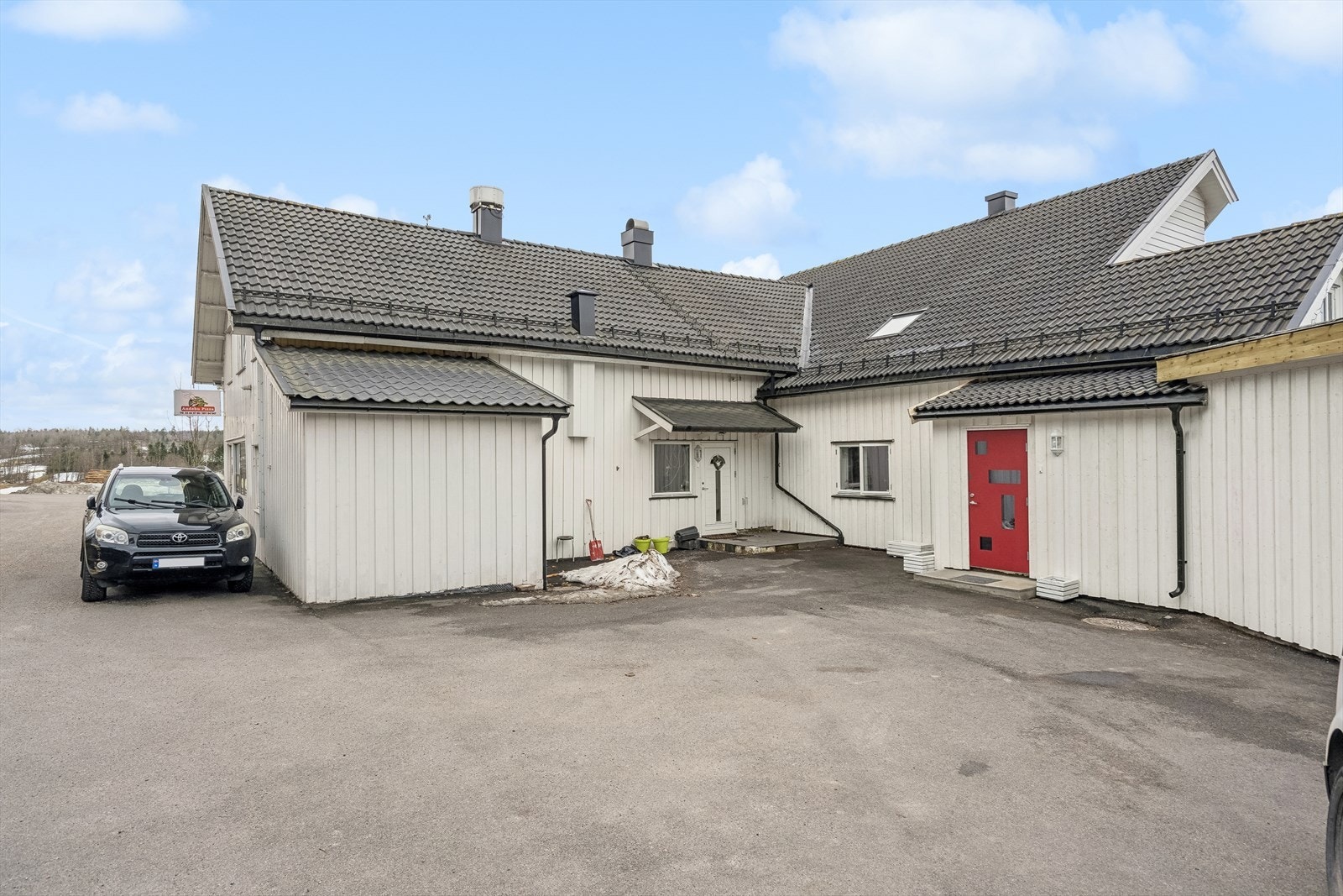 Leiligheten ligger i et kombinert boligbygg - inngangen til leiligheten ved den røde døren. Galleribilde