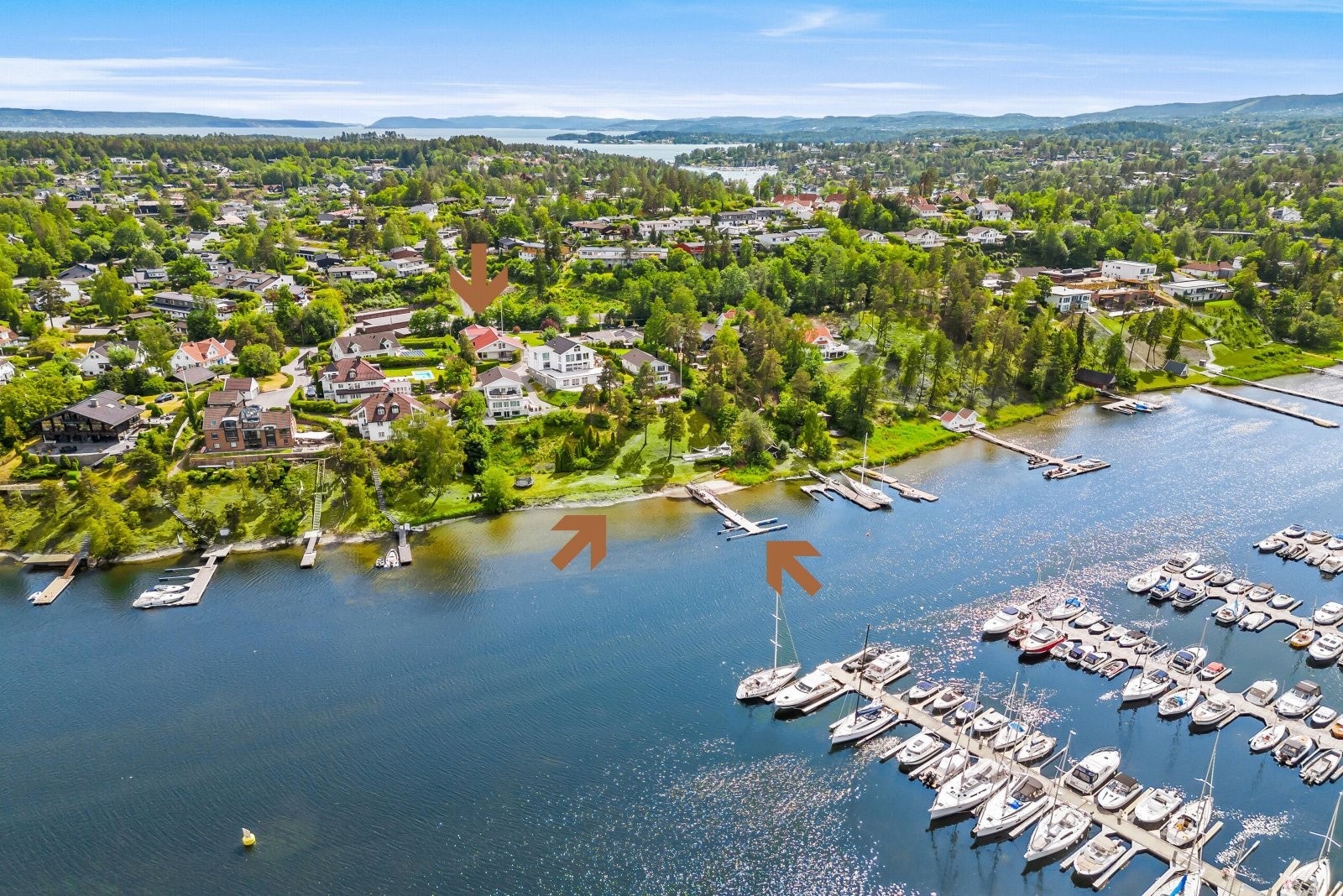 Oversiktsbilde - Eiendommen ligger i bakkant av strandparsellen som deles med tre naboer. Det medfølger flere båtplasser på byggen som er markert Galleribilde