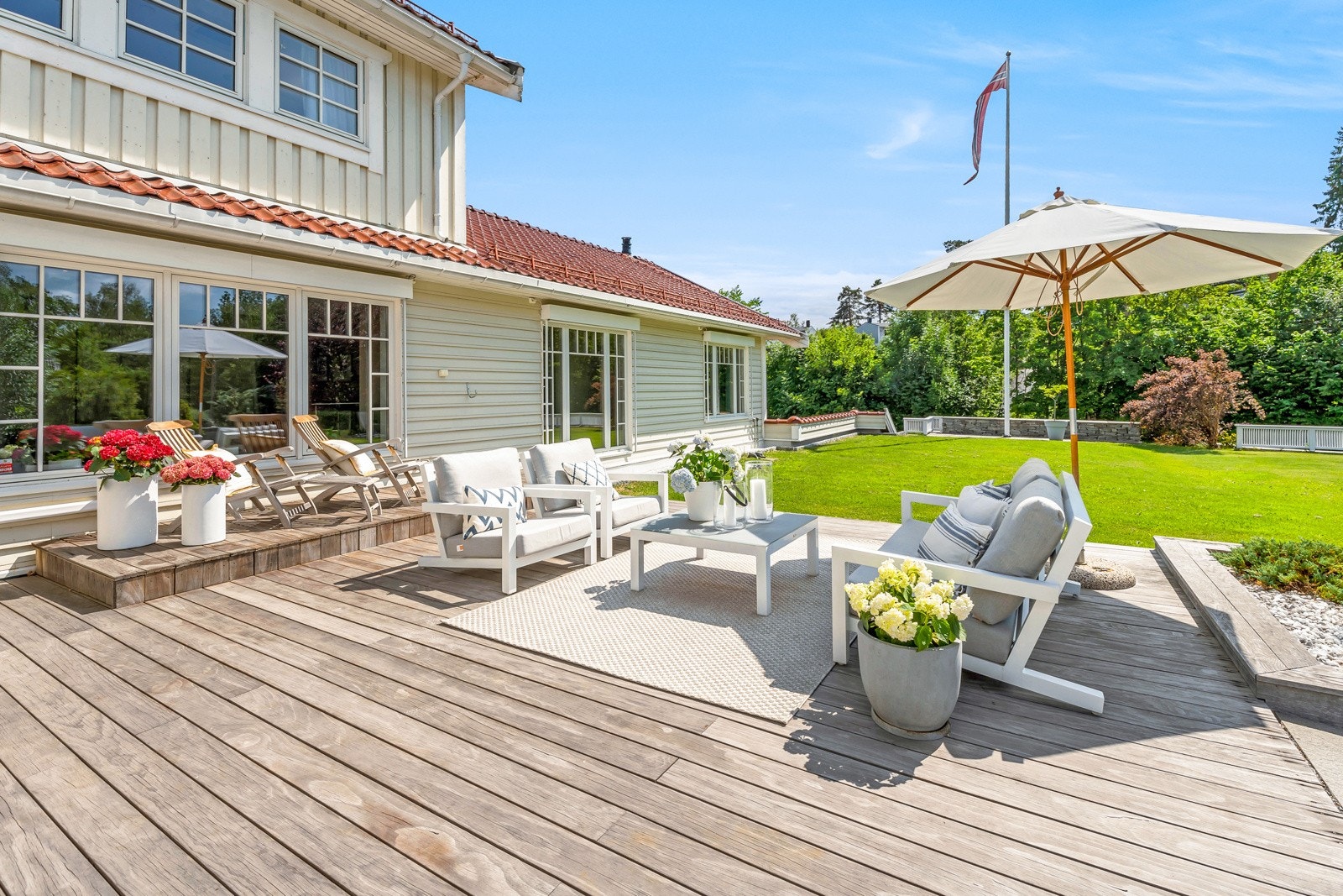 Eiendommen har flere, flotte uteområder som er opparbeidet og velholdt - Bilde fra terrassen på 45 kvm. med utgang fra 1. etasje Galleribilde