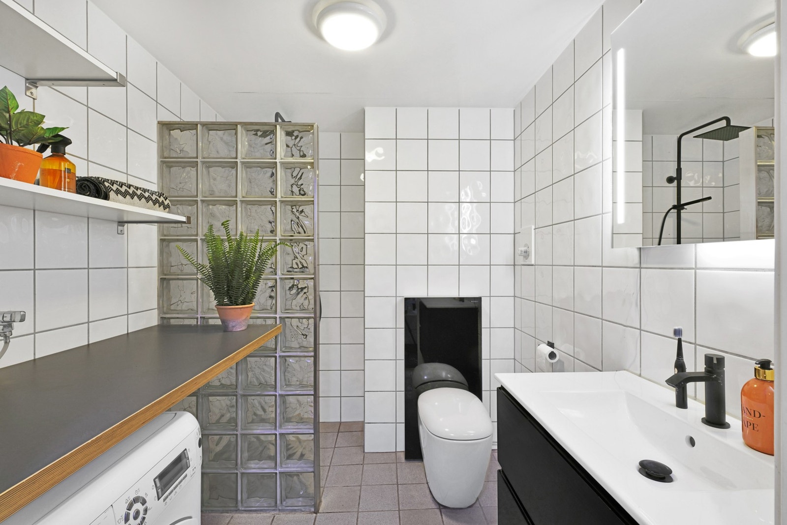 Badet er innredet med blant annet servant, speil, dusj og opplegg for vaskemaskin. Galleribilde