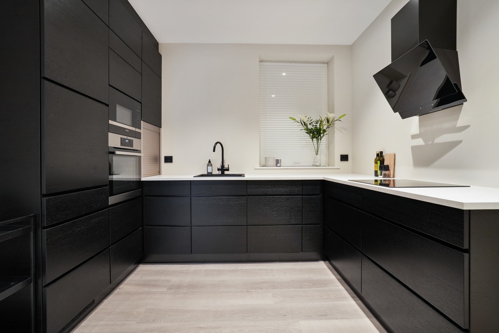 Stilfull kjøkkeninnredning fra Kvik med glatte, mørke fronter. Galleribilde