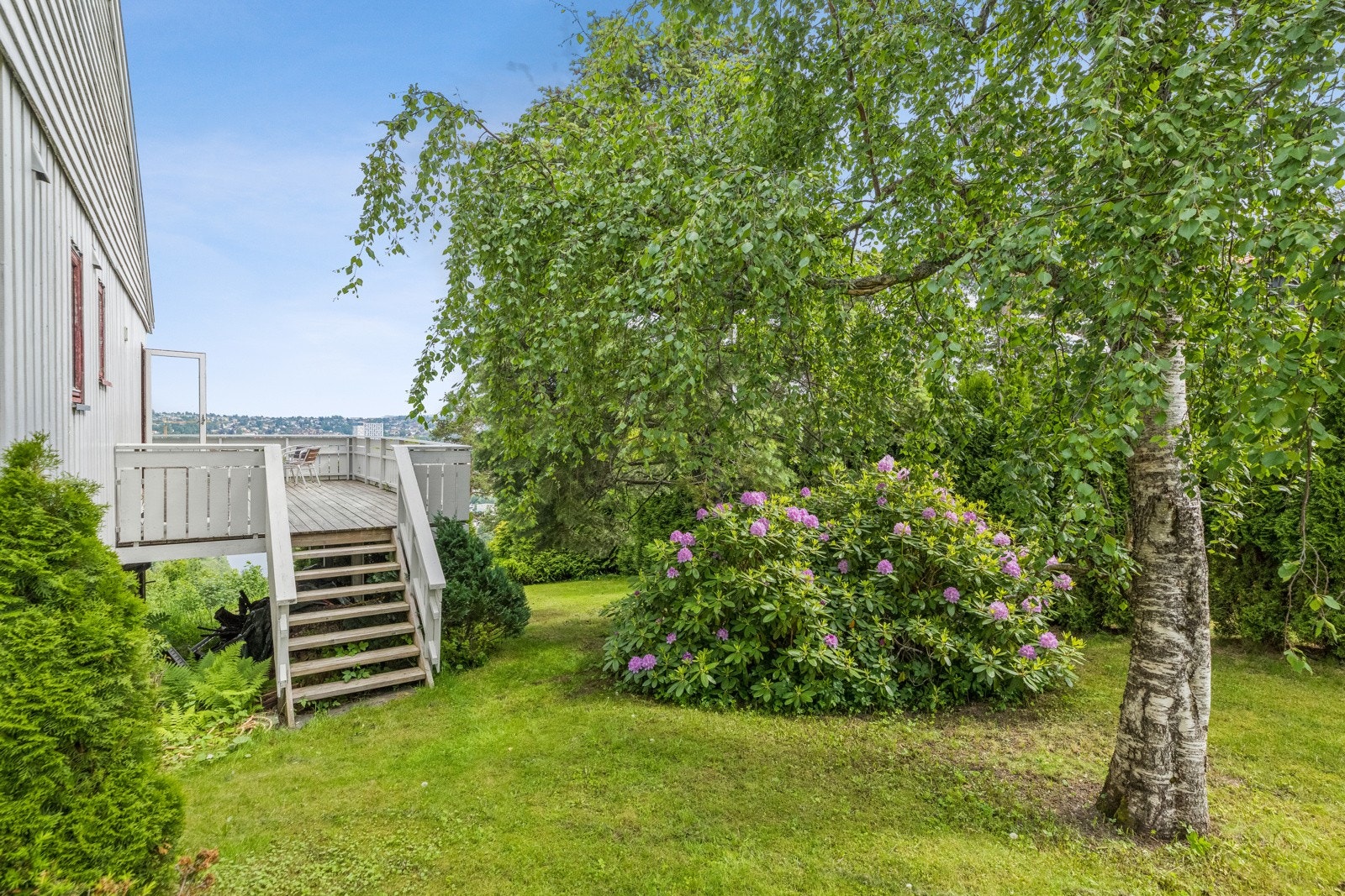 Verandaen ved kjøkkenet er sørvendt, med adkomst til den store, grønne hagen. Galleribilde
