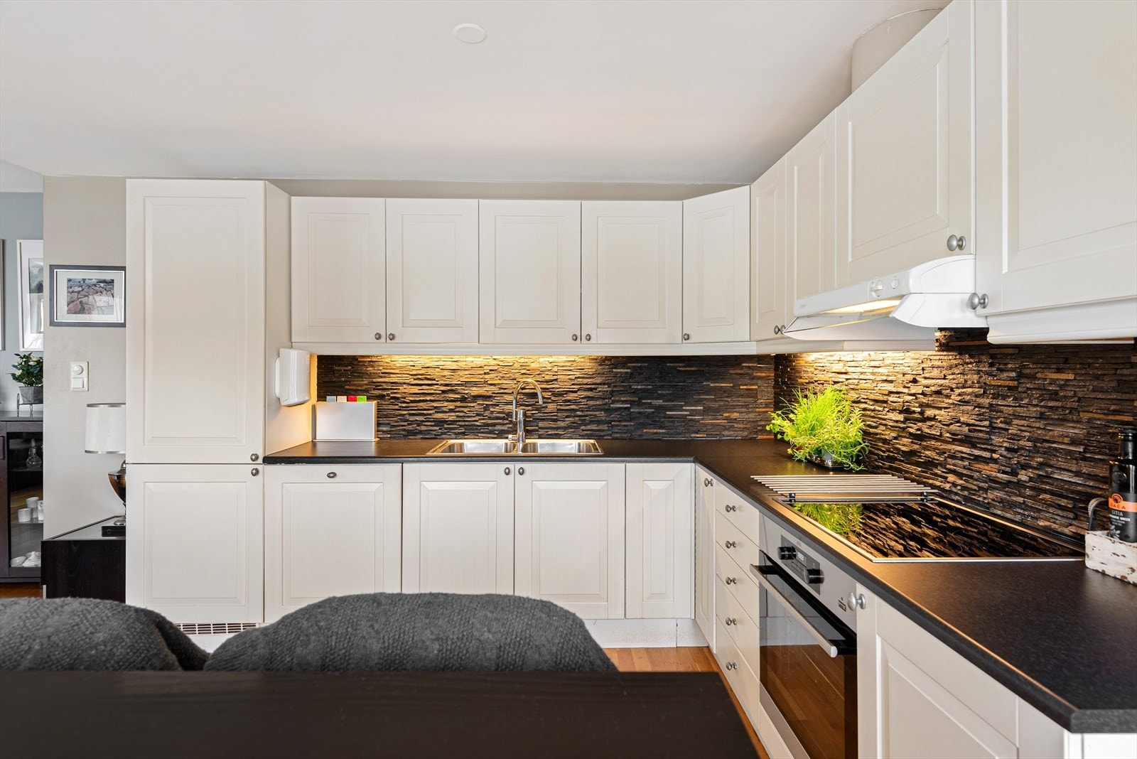 Kjøkkenet har innredning med profilerte fronter. Benkeplaten er av laminat. Det er kjøl/fryseskap, oppvaskmaskin, komfyr og induksjonstopp. Det er kjøkkenventilator med avtrekk ut. Galleribilde