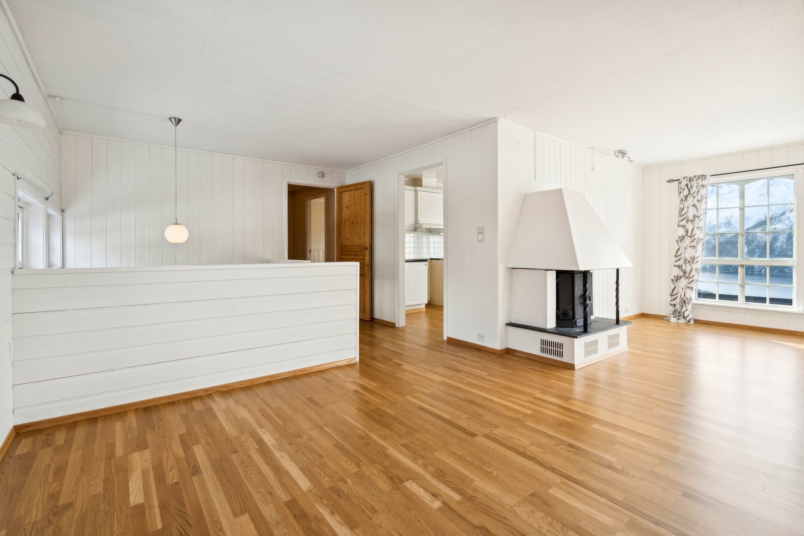 Lys og romslig stue med peis og store vindusflater. Galleribilde