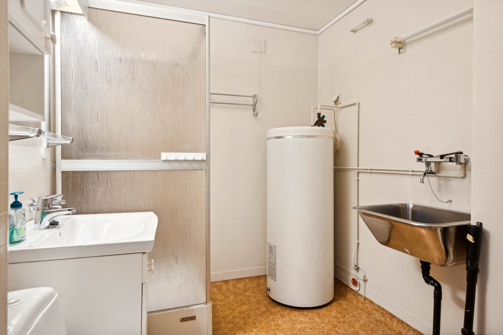 Her finner du i dag innredning med enkel vask, dusjkabinett, stålvask med røropplegg for vaskemaskin og gulvmontert toalett. Galleribilde