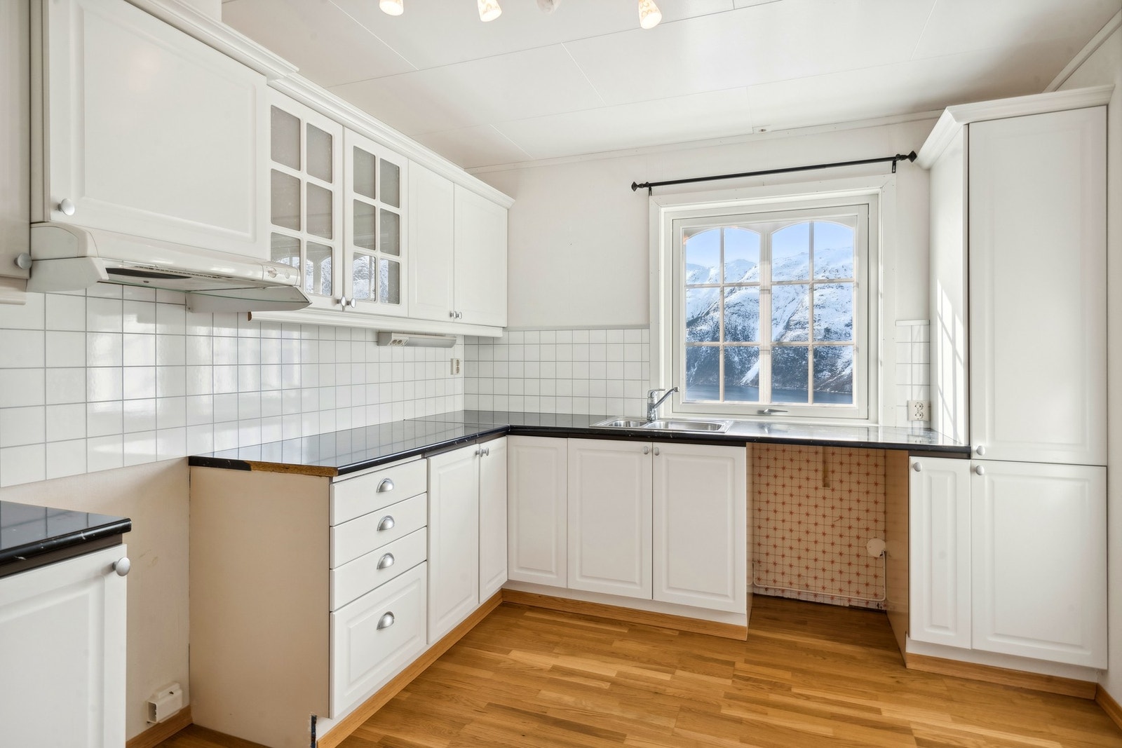 Kjøkkenet har original innredning med benkeplate av laminat, kitchenboard mellom benk og overskap og kjøkkenventilator med avtrekk via felles avtrekksmotor på kaldloft. Galleribilde