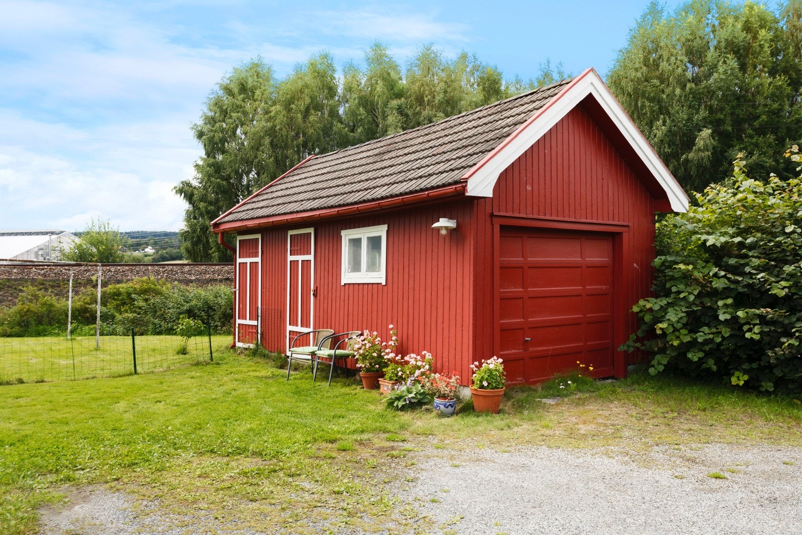 Garasjen har en stor bod i bakkant. Galleribilde