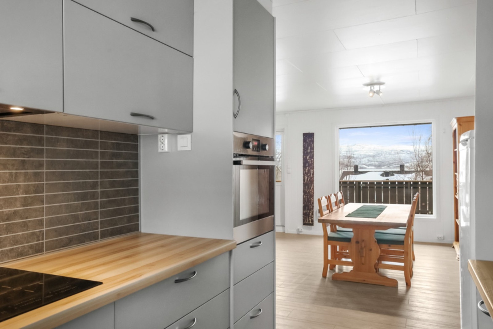Benkeplate av laminat, innredning med glatte fronter og frittstående kjøleskap. Galleribilde