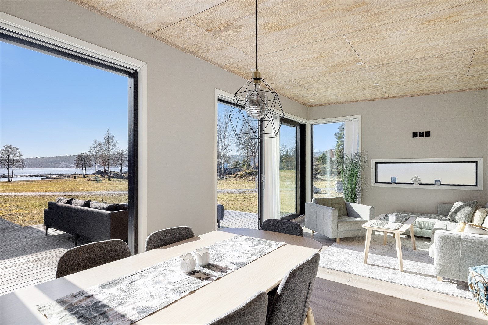 Utgang til solfylt markterrasse med nydelige utsiktsforhold via skyvedører fra kjøkken/stue Galleribilde