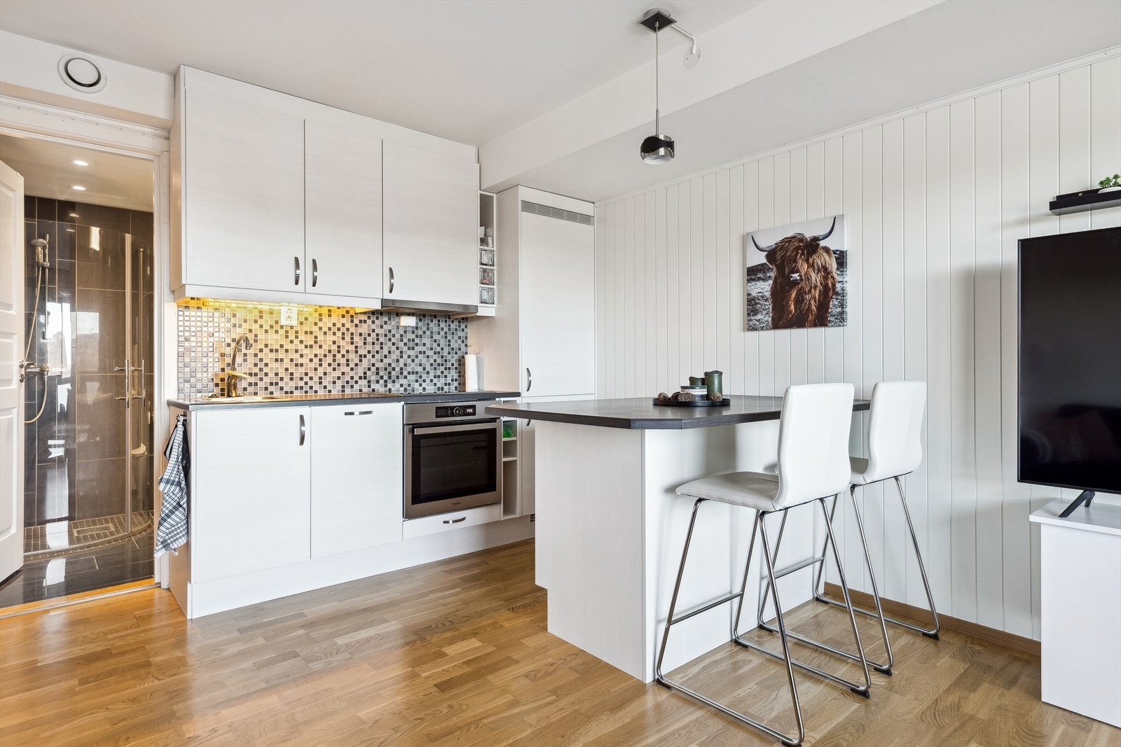 Kjøkkenet i utleiedelen er stilrent og arealeffektivt med flere integrerte hvitevarer. Ny stekeovn i 2022. Galleribilde