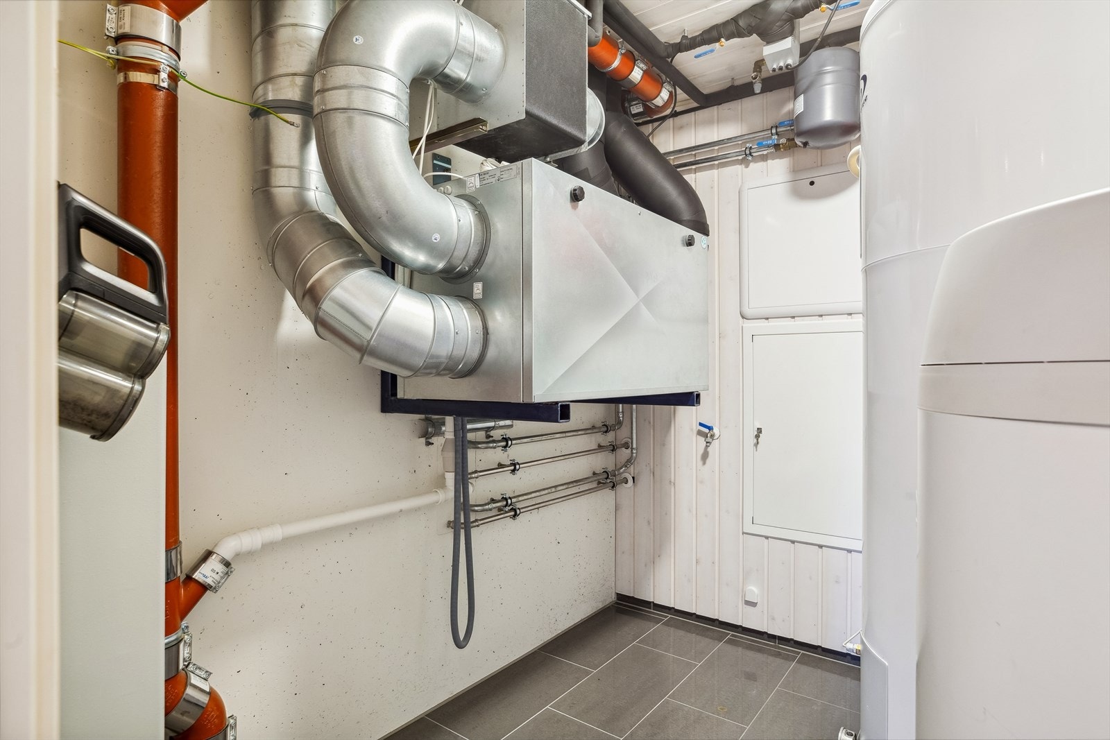 Teknisk rom i sokkeletasje. Her har man tilgang til boligens styresystem for vannbåren varme, ventilasjon, strømskap m.m. Galleribilde