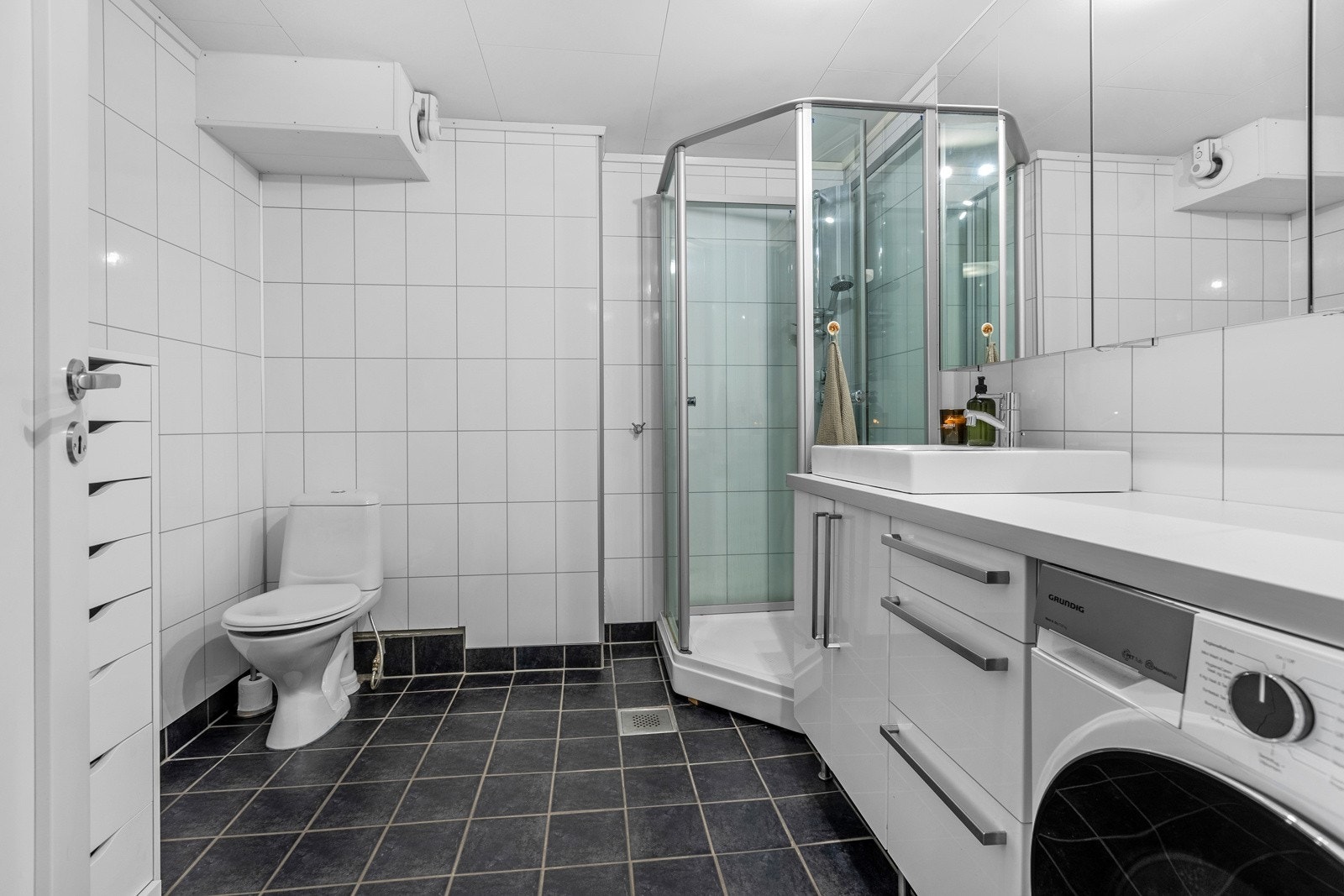 Badet er flislagt med varmekabler, flislagte hvite fliser på vegg og takess i himling Galleribilde